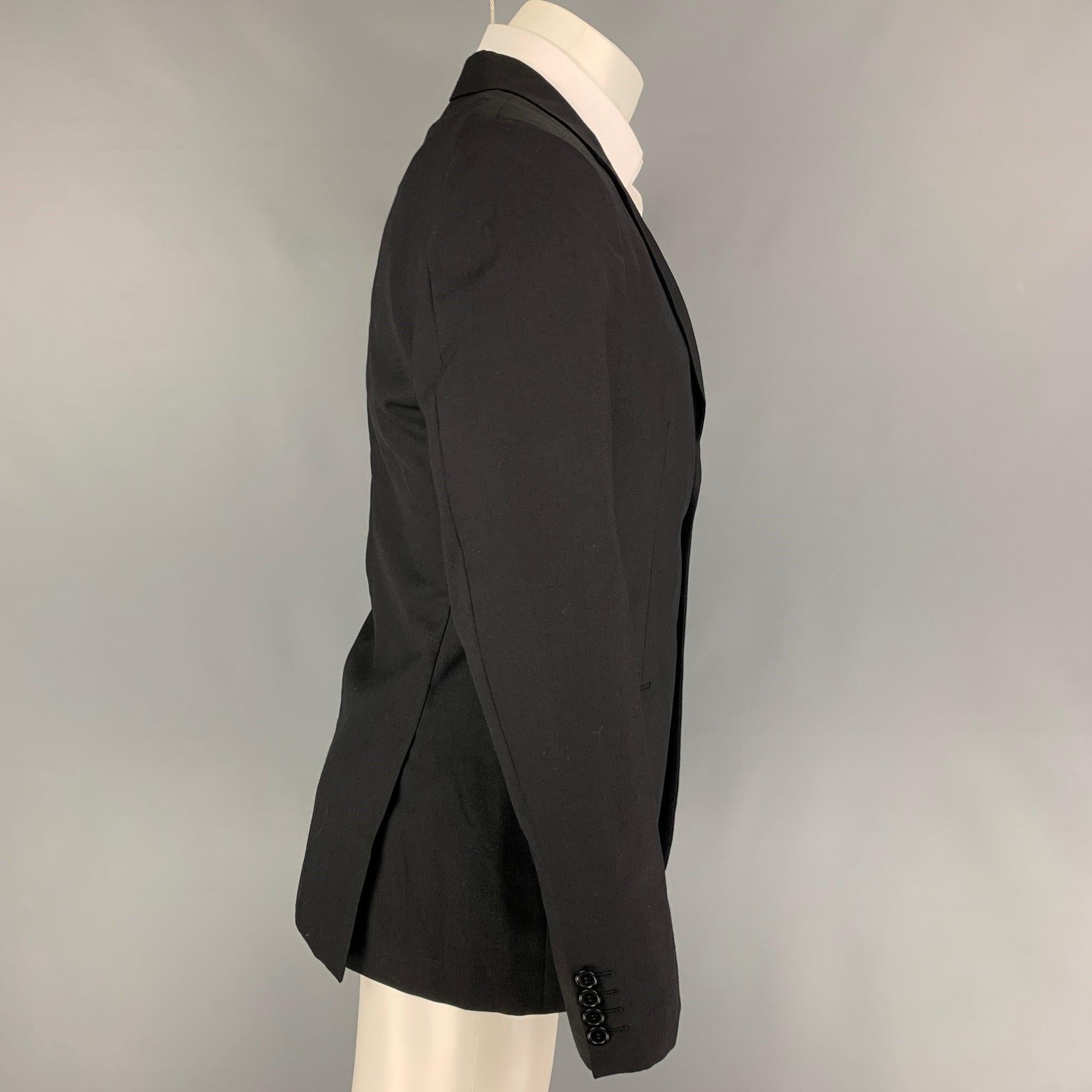 CALVIN KLEIN COLLECTION sport coat comes in a black wool with a full liner featuring a notch lapel, flap pockets, double back vent, and a double button closure.
Very Good
Pre-Owned Condition. 

Marked:   48/38 

Measurements: 
 
Shoulder:
17.5