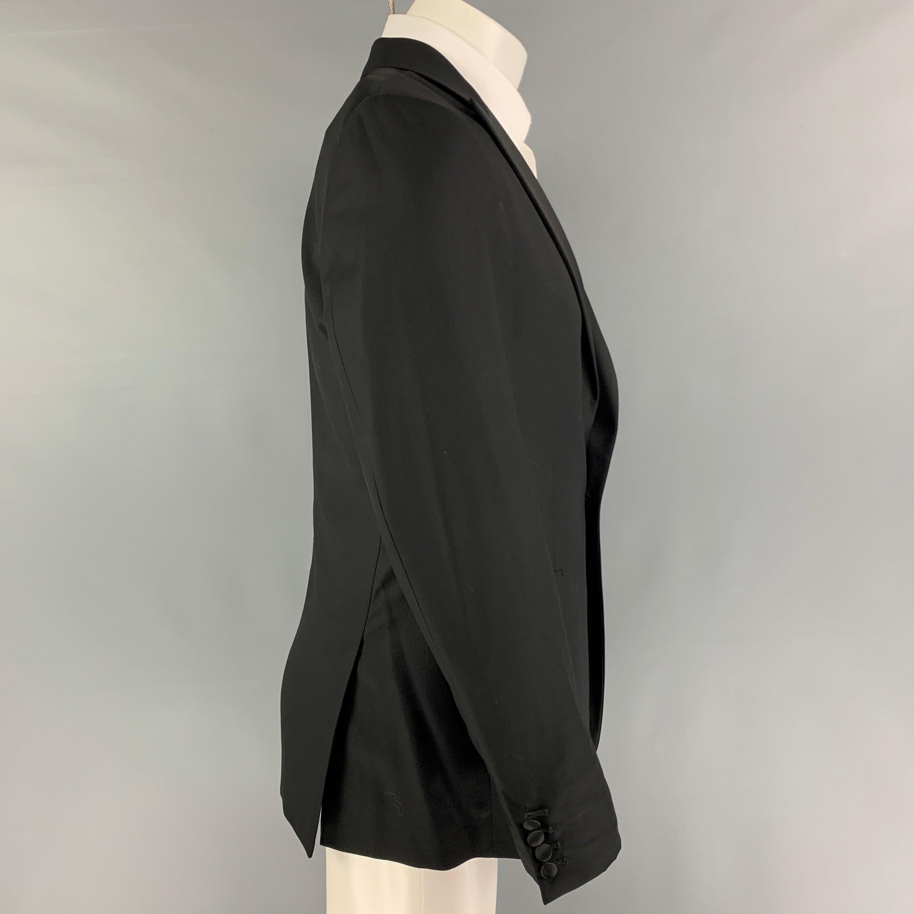 CALVIN KLEIN COLLECTION sport coat comes in a black wool with a full liner featuring a peak lapel, flap pockets, double back vent, and a single button closure.
Very Good
Pre-Owned Condition. 

Marked:   48/38 

Measurements: 
 
Shoulder: 17 inches 