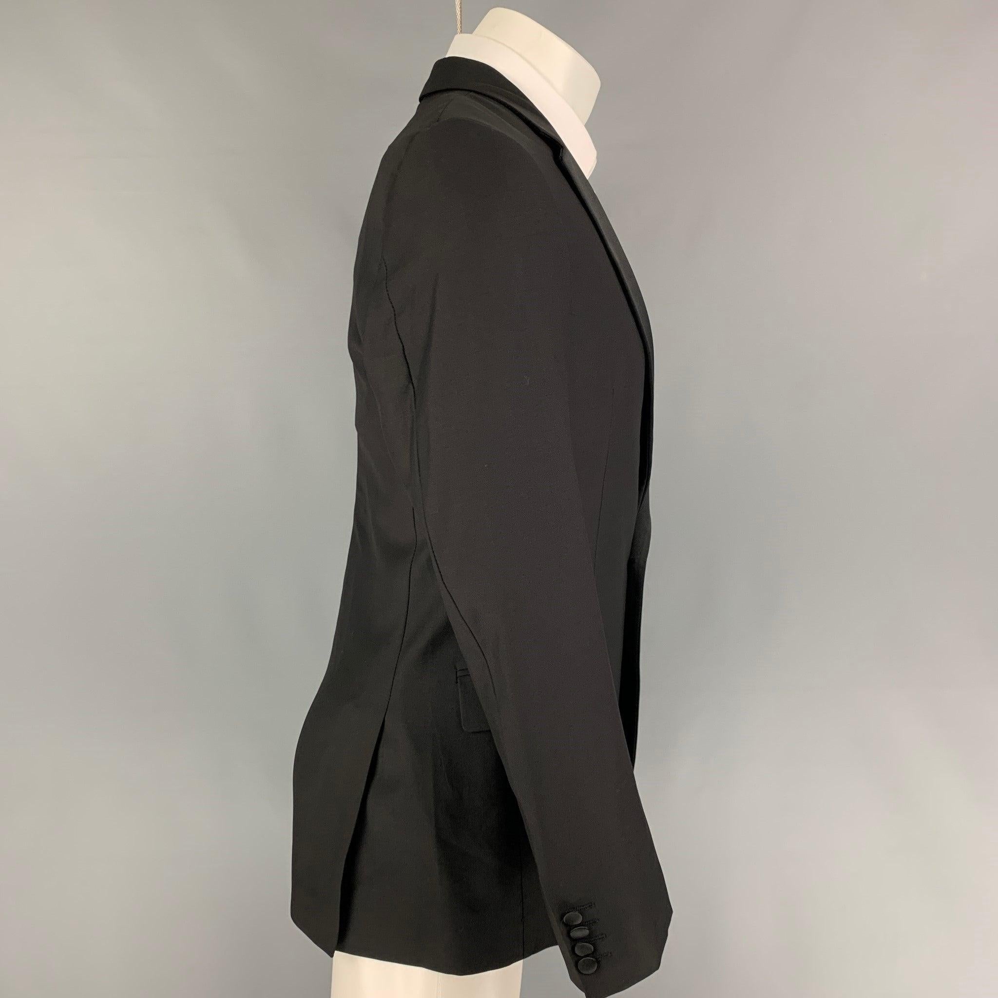 CALVIN KLEIN COLLECTION tuxedo sport coat comes in a black wool with a full liner featuring a notch lapel, flap pockets, double back vent, an a single button closure.
Very Good
Pre-Owned Condition. 

Marked:   48/38 

Measurements: 
 
Shoulder: 17.5