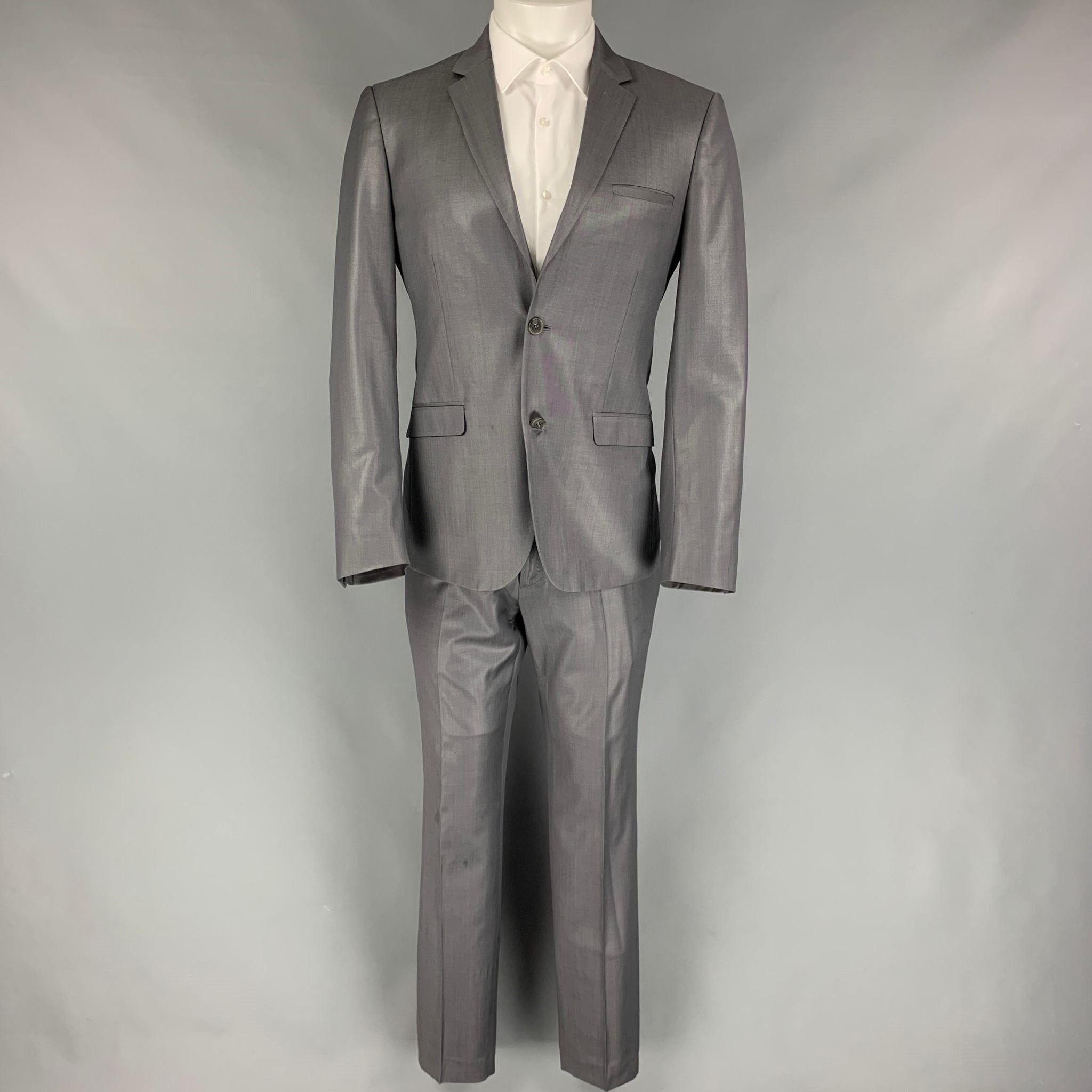 CALVIN KLEIN COLLECTION suit comes in a dark wool with a full liner and includes a single breasted, double button sport coat with a notch lapel and matching flat front trousers.

Very Good Pre-Owned Condition.
Marked: