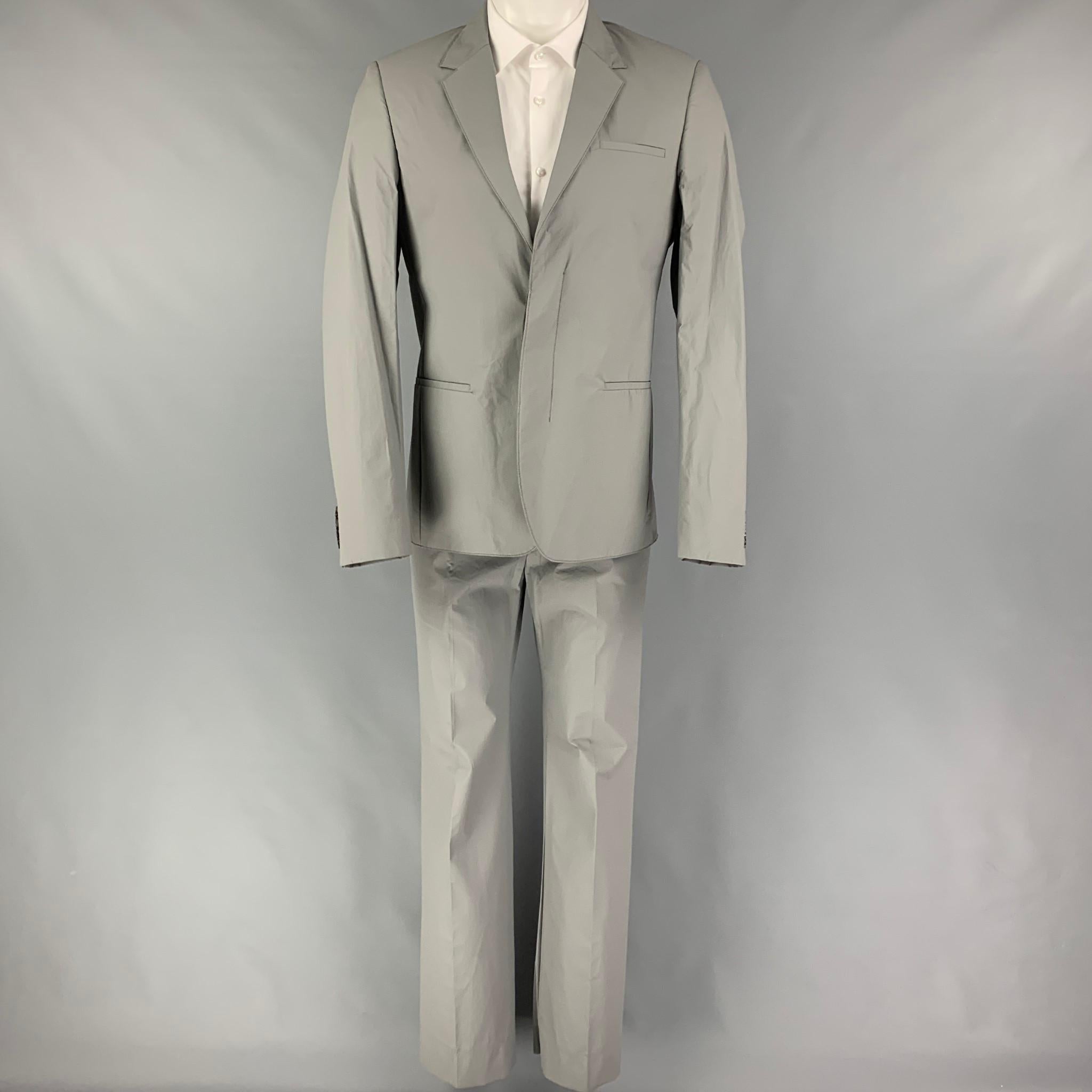 CALVIN KLEIN COLLECTION suit comes in a grey polyurethane / polyester with a full liner and includes a single breasted, double button sport coat with a notch lapel and matching flat front trousers. Made in Italy.

New With Tags.
Marked: