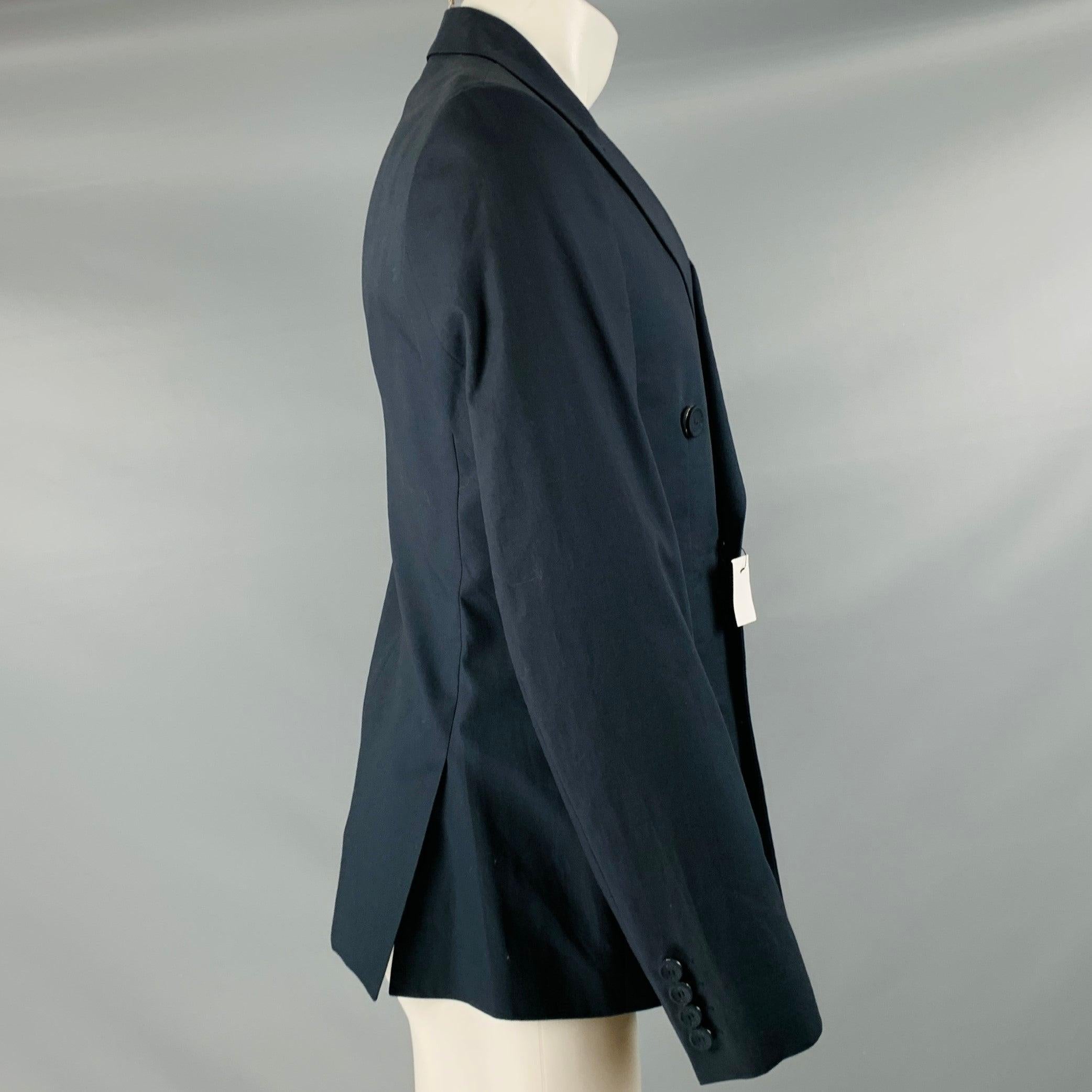 CALVIN KLEIN COLLECTION sport coat in a navy cotton fabric featuring peak lapel, double vented back, and double breasted double button closure. Made in Italy.Very Good Pre-Owned Condition. Minor signs of wear. 

Marked:   48/38 

Measurements: 
