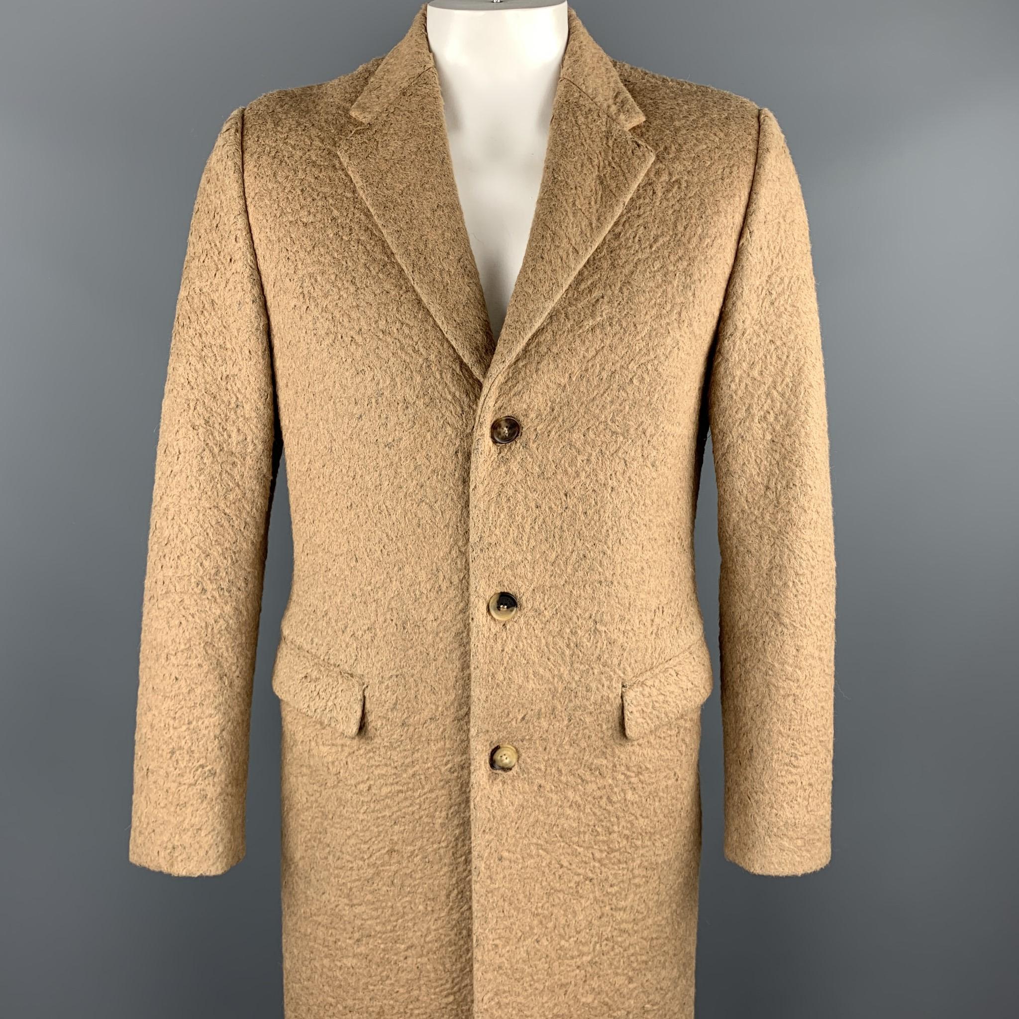 CALVIN KLEIN COLLECTION coat comes in a tan textured wool blend featuring a notch lapel, flap pockets, and a three button closure. Made in Italy.

Very Good Pre-Owned Condition.
Marked: IT 48

Measurements:

Shoulder: 17 in. 
Chest: 40 in. 
Sleeve: