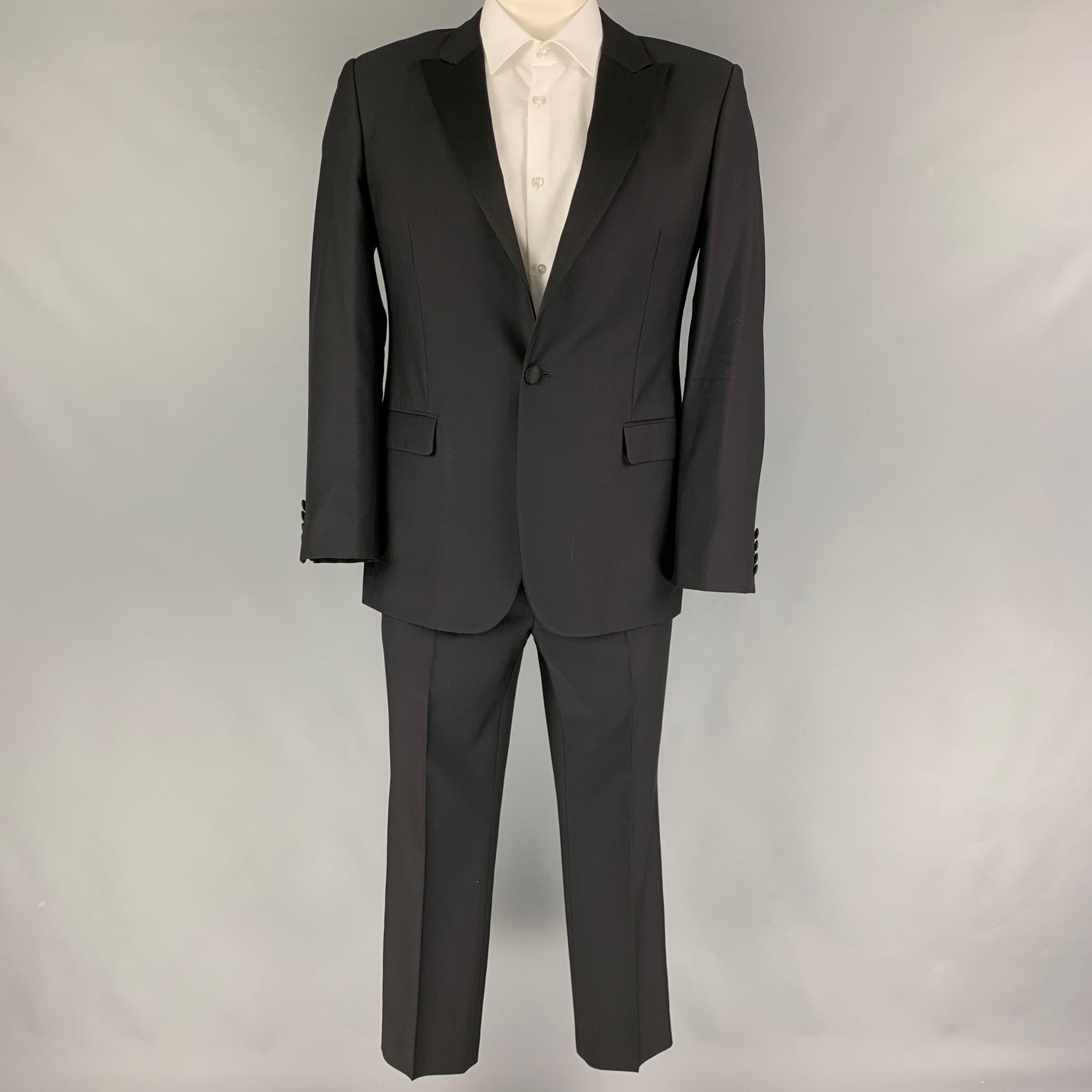 CALVIN KLEIN COLLECTION suit comes in a black wool with a full liner and includes a single breasted, single button sport coat with a peak lapel and matching flat front trousers.

Very Good Pre-Owned Condition.
Marked: