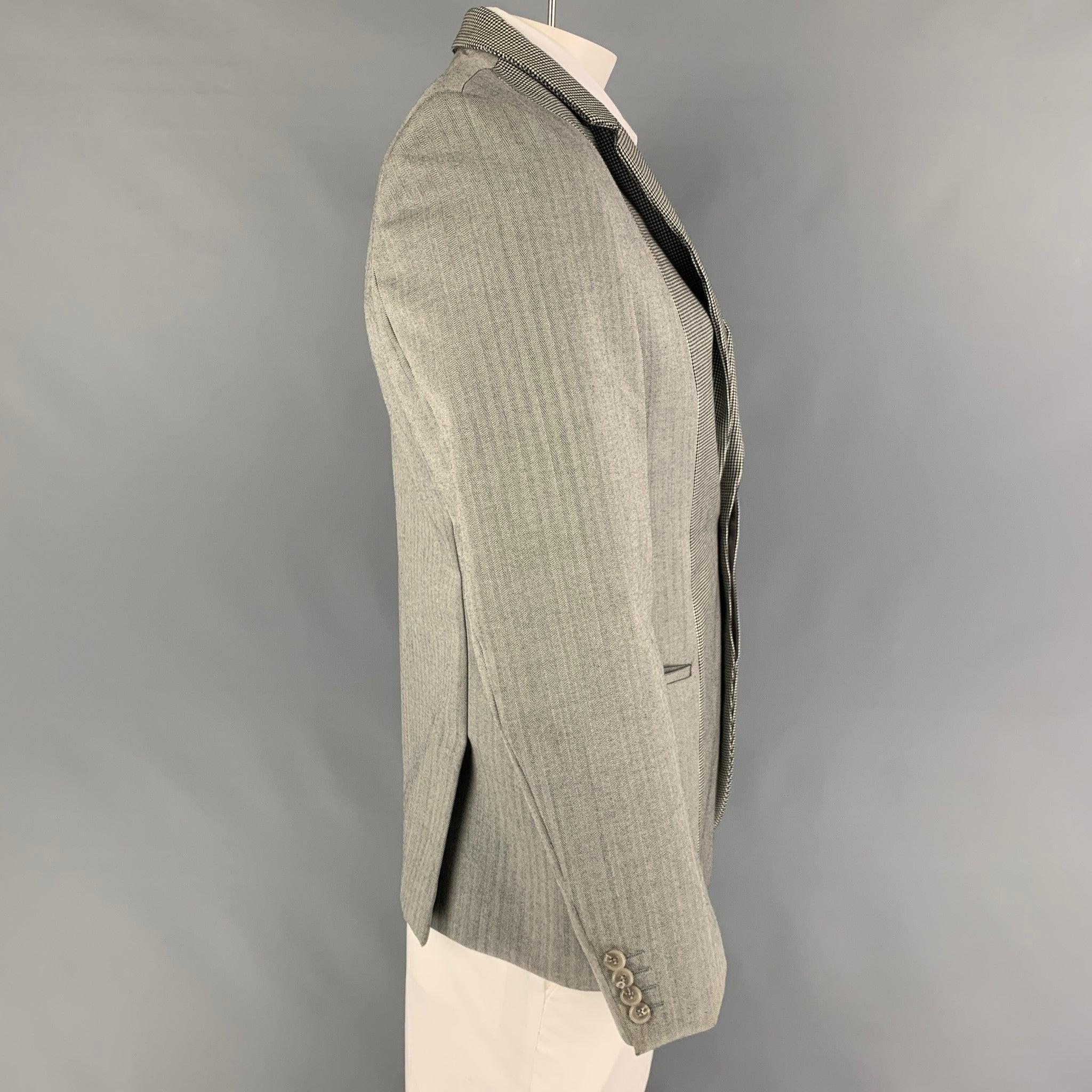 CALVIN KLEIN COLLECTION sport coat comes in a grey & black wool with a full liner featuring a notch lapel, slit pockets, double back vent, and a hidden double button closure.
Very Good
Pre-Owned Condition. 

Marked:   50/40 

Measurements: 
