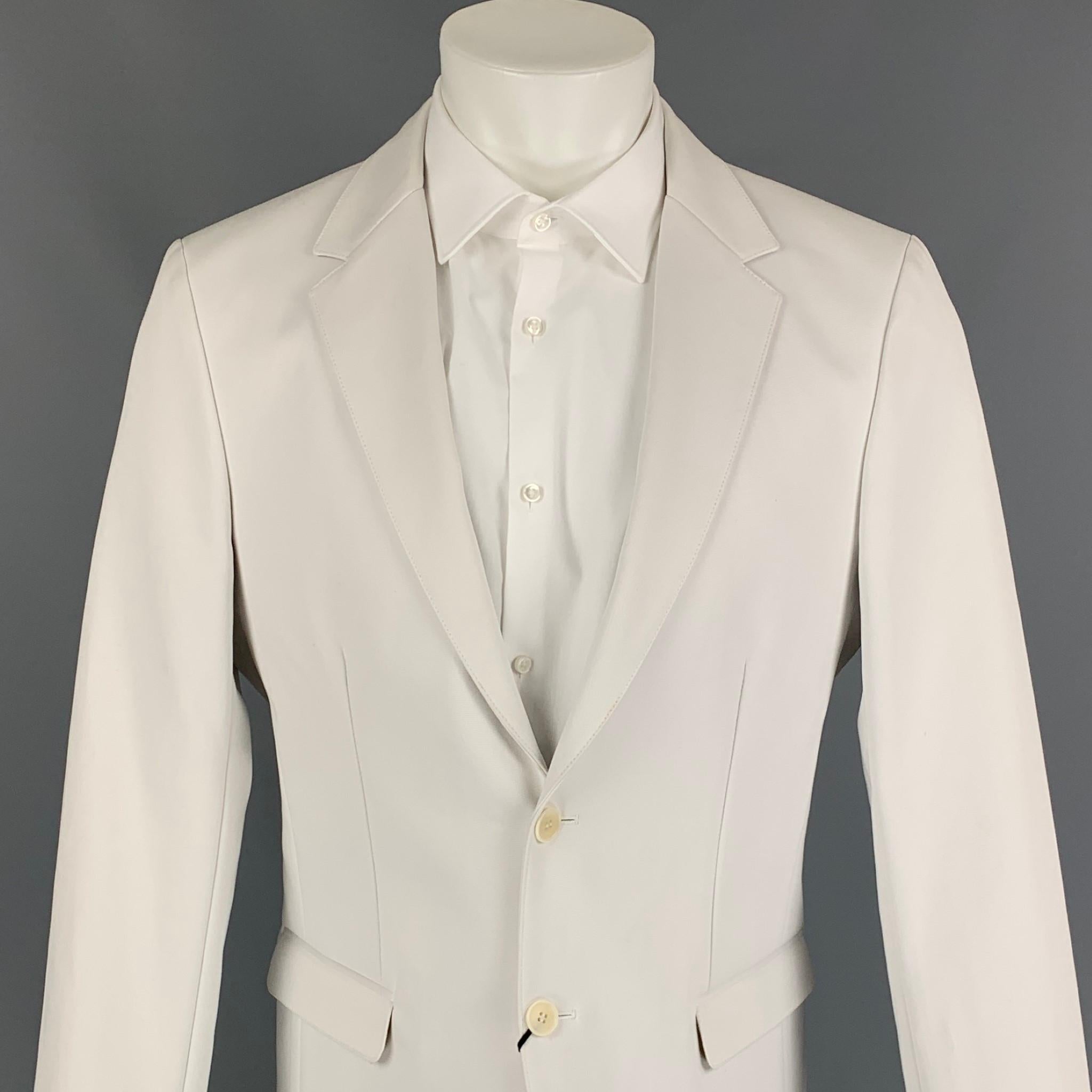 CALVIN KLEIN COLLECTION sport coat comes in a off white cotton featuring a notch lapel, flap pockets, and a double button closure. 

New With Tags. 
Marked: 50/40
Original Retail Price: $975.00

Measurements:

Shoulder: 18 in.
Chest: 40 in.
Sleeve: