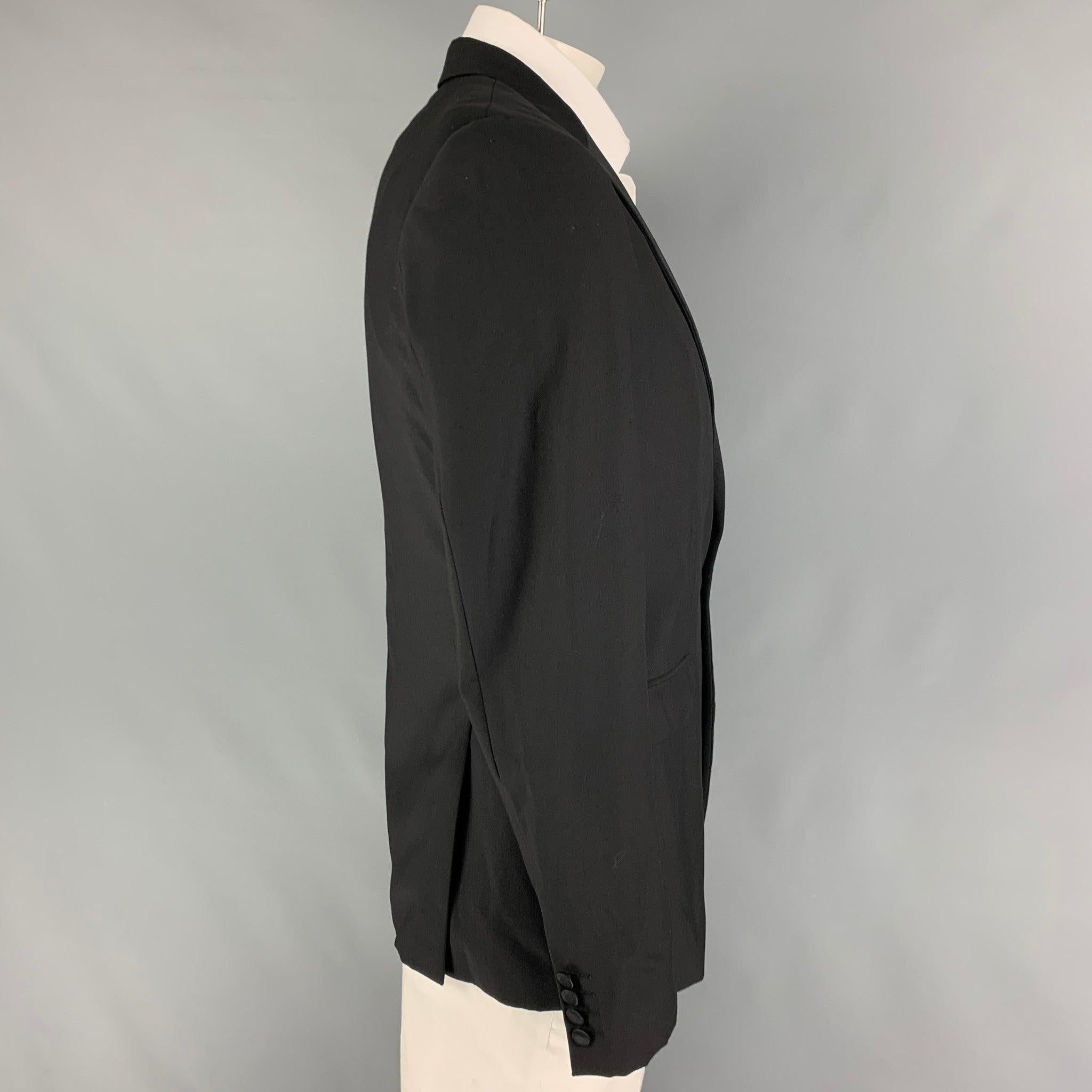 CALVIN KLEIN COLLECTION sport coat comes in a black wool with a full liner featuring a peak lapel, flap pockets, double back vent, and a single button closure.
Very Good
Pre-Owned Condition. 

Marked:   50/40 

Measurements: 
 
Shoulder: 18 inches 