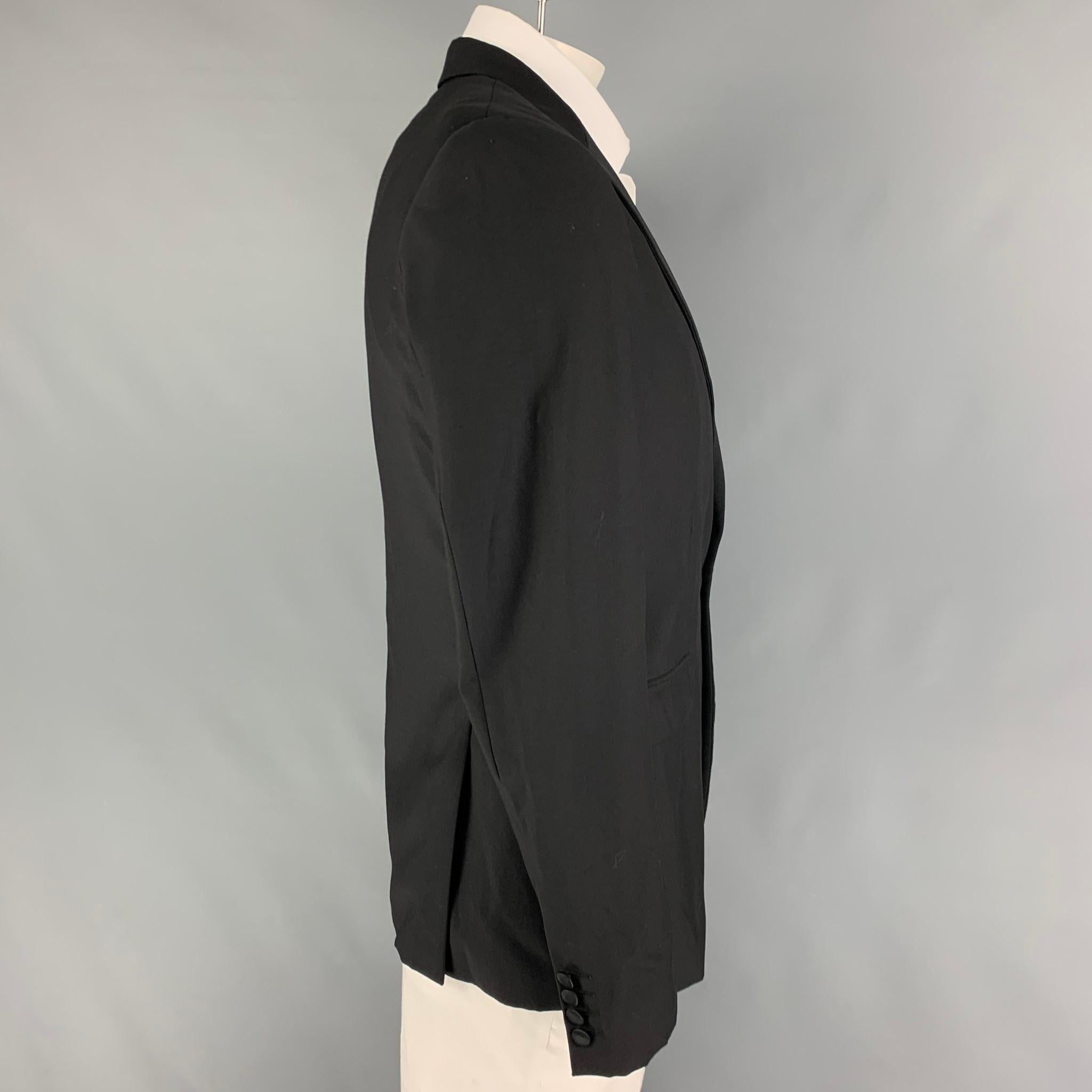 CALVIN KLEIN COLLECTION sport coat comes in a black wool with a full liner featuring a peak lapel, flap pockets, double back vent, and a single button closure. 

Very Good Pre-Owned Condition.
Marked: 50/40

Measurements:

Shoulder: 18 in.
Chest: 40