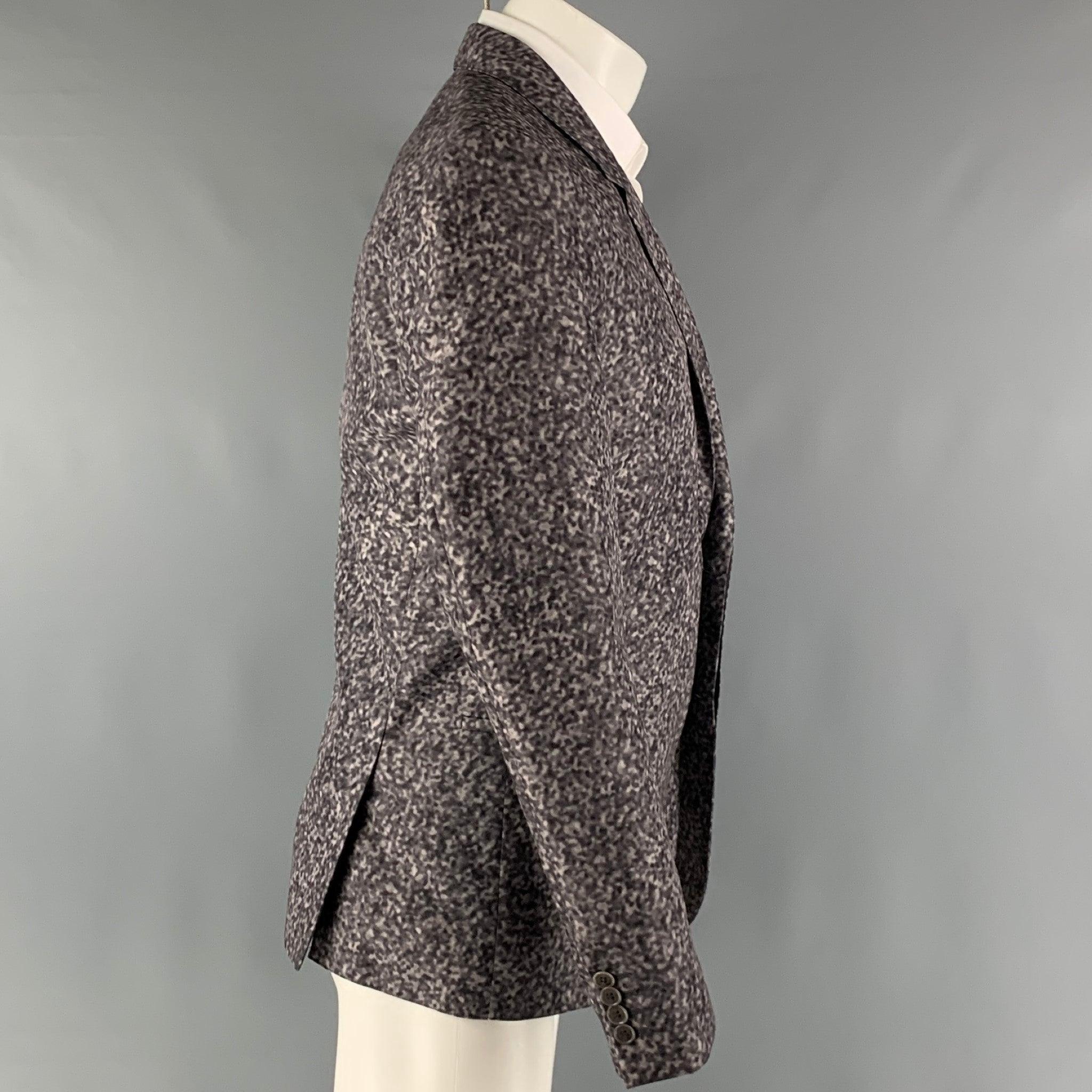 CALVIN KLEIN COLLECTION sport coat comes in a gray abstract print polyester woven material with a full liner and includes a single breasted, single button hidden closure, notch lapel and double back vent. Excellent Pre-Owned Condition. 

Marked:  