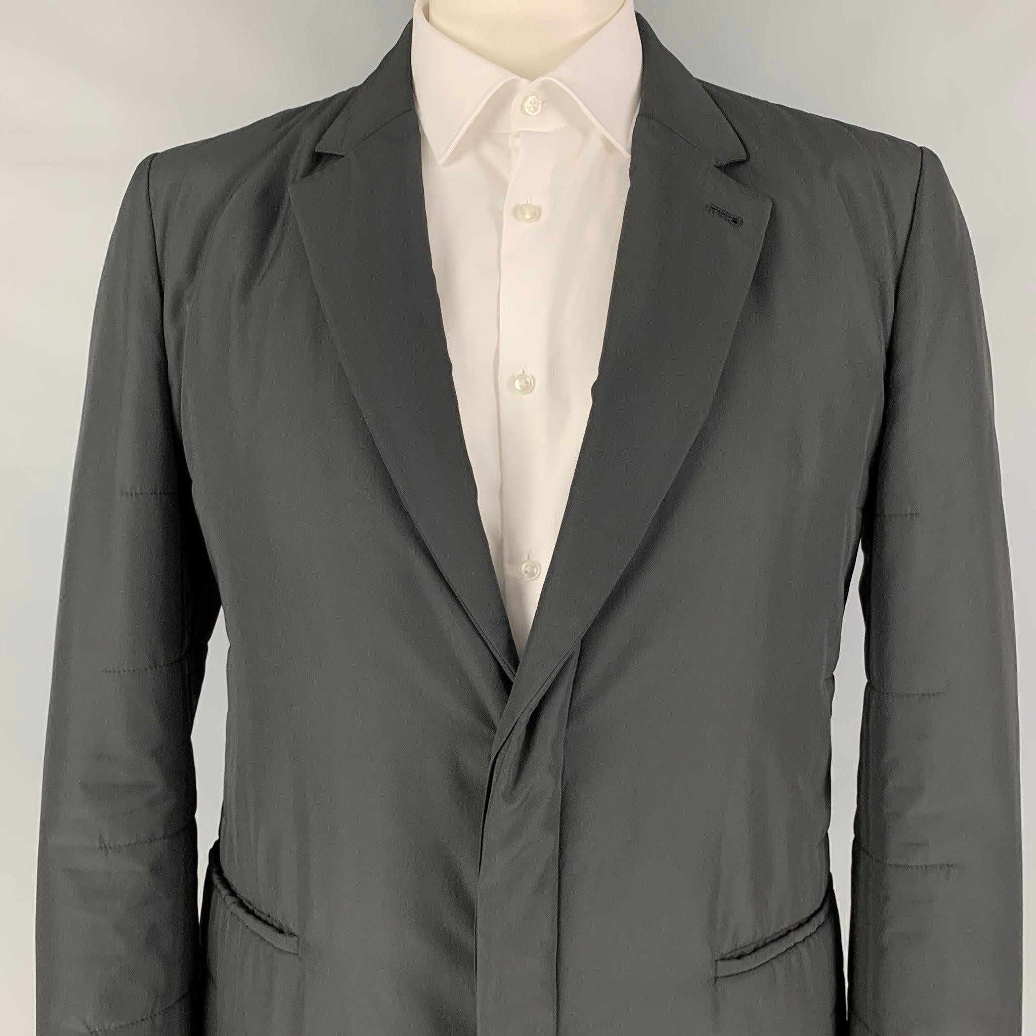 CALVIN KLEIN COLLECTION sport coat in a black quilted polyester with a full liner featuring a notch lapel, slit pockets, and a hidden double button closure.
Excellent
Pre-Owned Condition. 

Marked:   IT 54 

Measurements: 
 
Shoulder: 18.5 inches 
