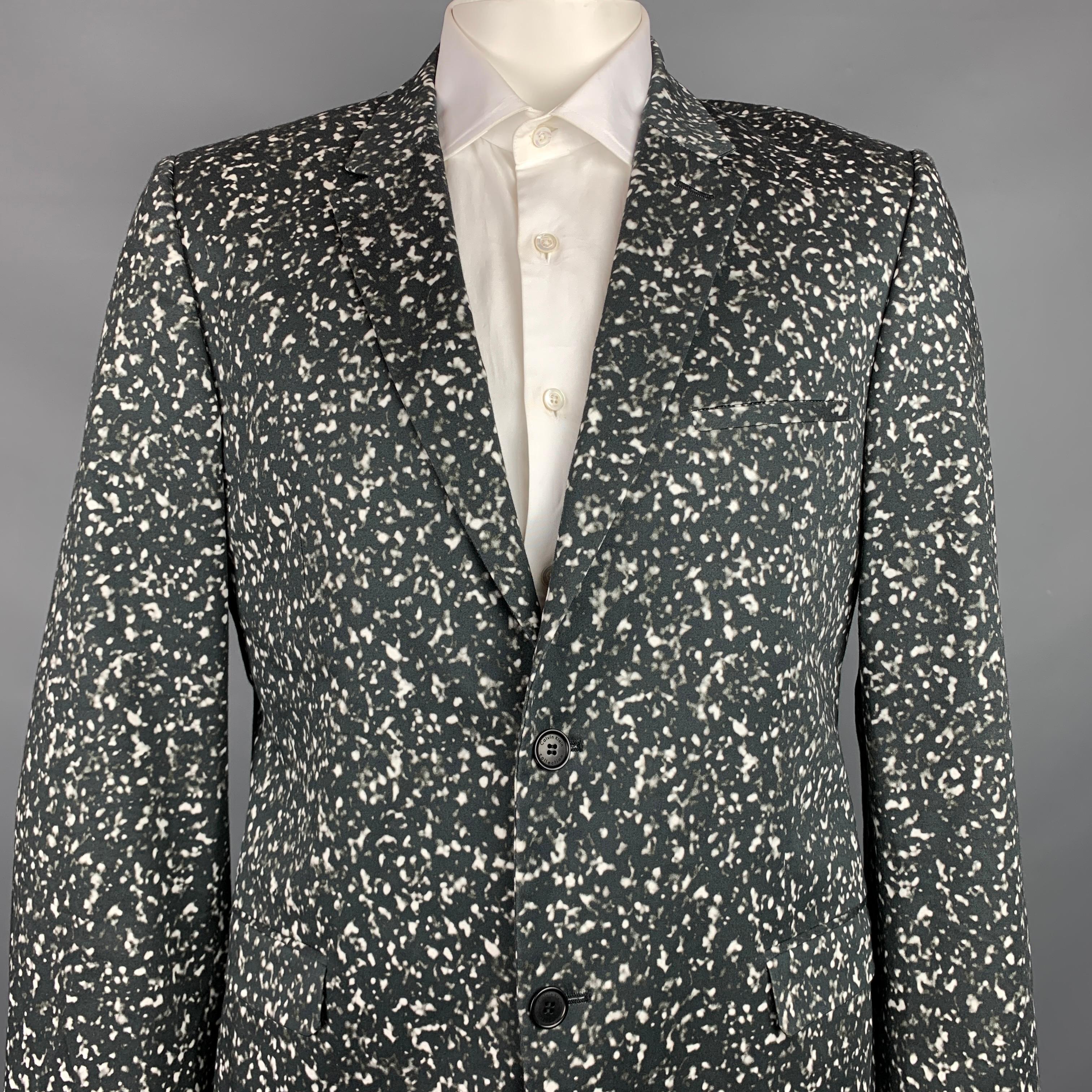 CALVIN KLEIN COLLECTION sport coat comes in a black & white print cotton with a full liner featuring a notch lapel, flap pockets, and a single button closure. Made in USA.

Very Good Pre-Owned Condition.
Marked: 54/44

Measurements:

Shoulder: 19