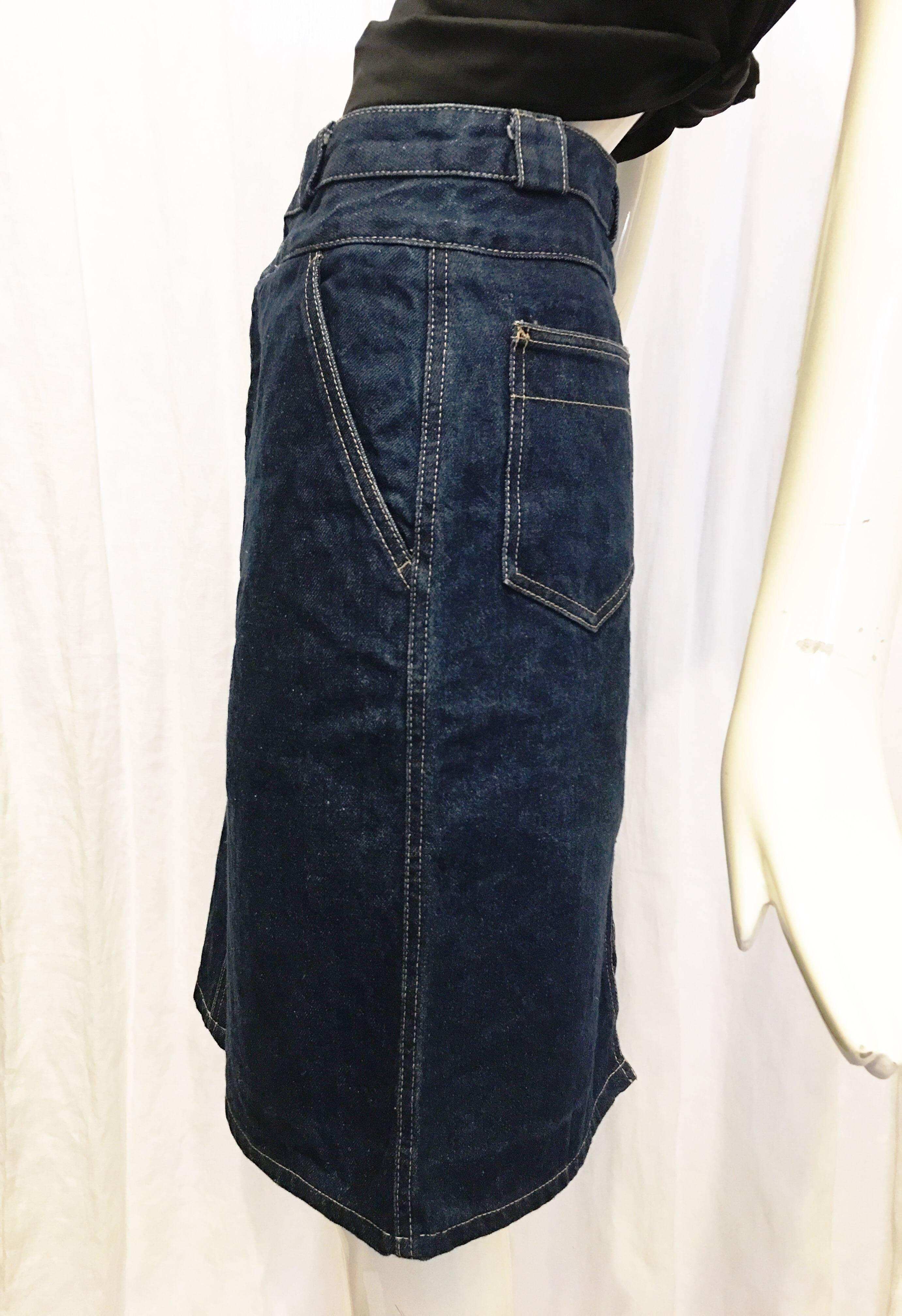 Classic denim pencil skirt from Calvin Klein. Two front pockets at hips. Double waist band with a button at each. Zipper fly beneath buttons. Two back pockets. 6.5 inch slit at back hem. Denim is on the stiff side, not much give. Skirt looks unworn.