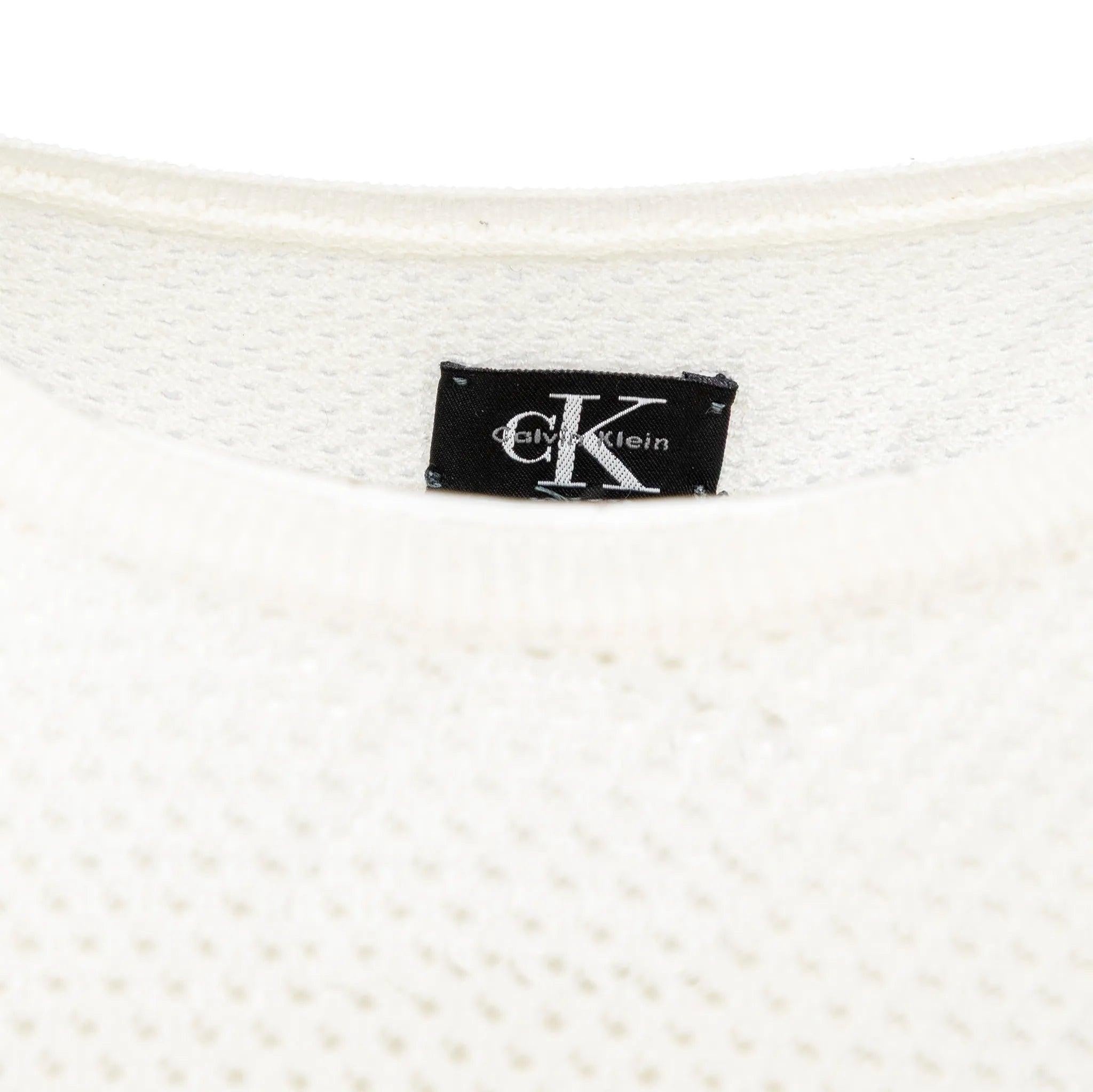 Calvin Klein off-white knitwear set featuring a perforated design, includes a sleeveless top and button-closure cardigan in soft acrylic fabric.  
 Measurements: Top Shoulder:25;Bust:38;Length:52;Cardigan Shoulder:32;Bust:42;Length:52  
 Material: