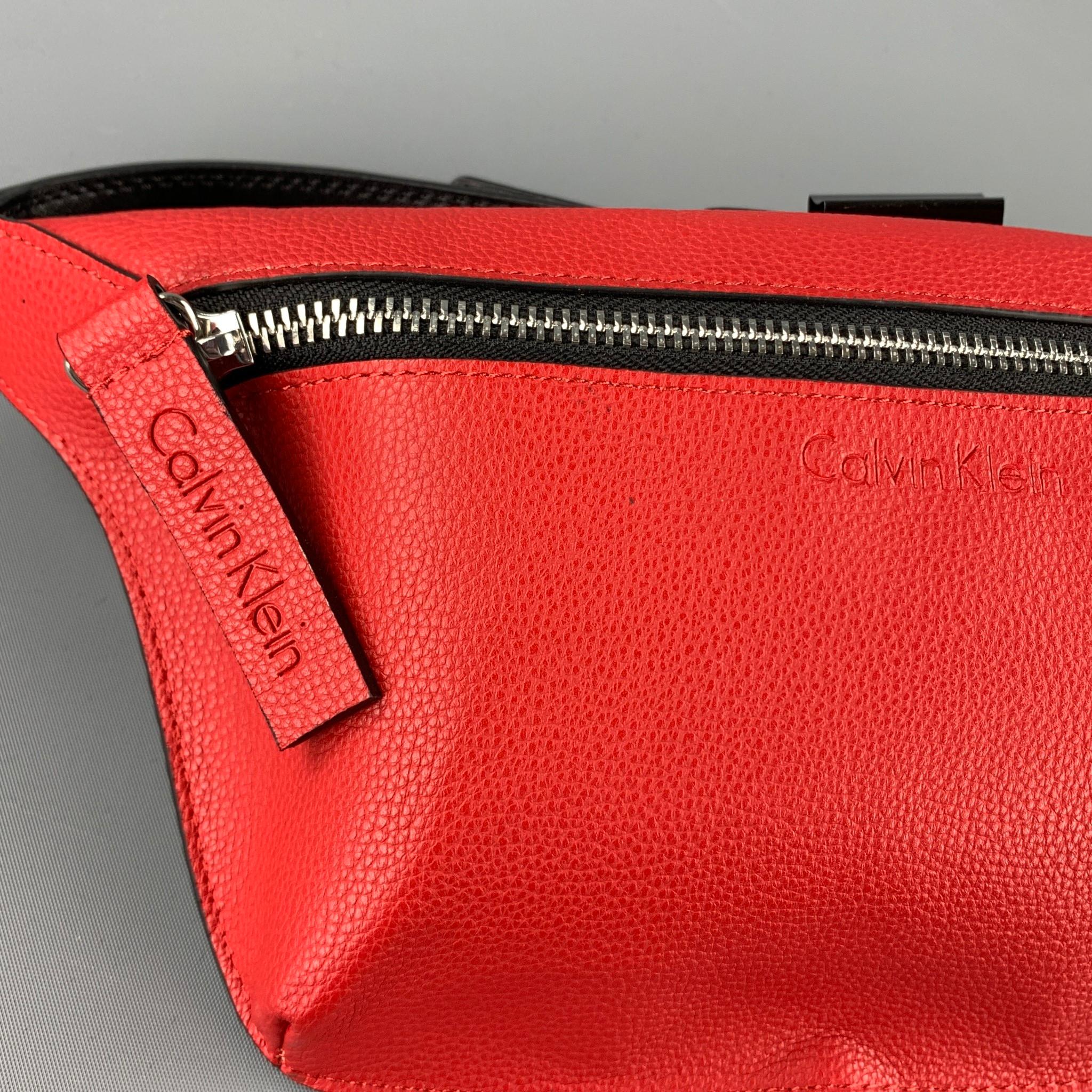 CALVIN KLEIN fanny pack comes in a red pebble grain leather featuring an adjustable strap closure and a front zip up closure.

Brand New. 

Measurements:

Length: 12 in.
Width: 1 in.
Height: 5.5 in.
