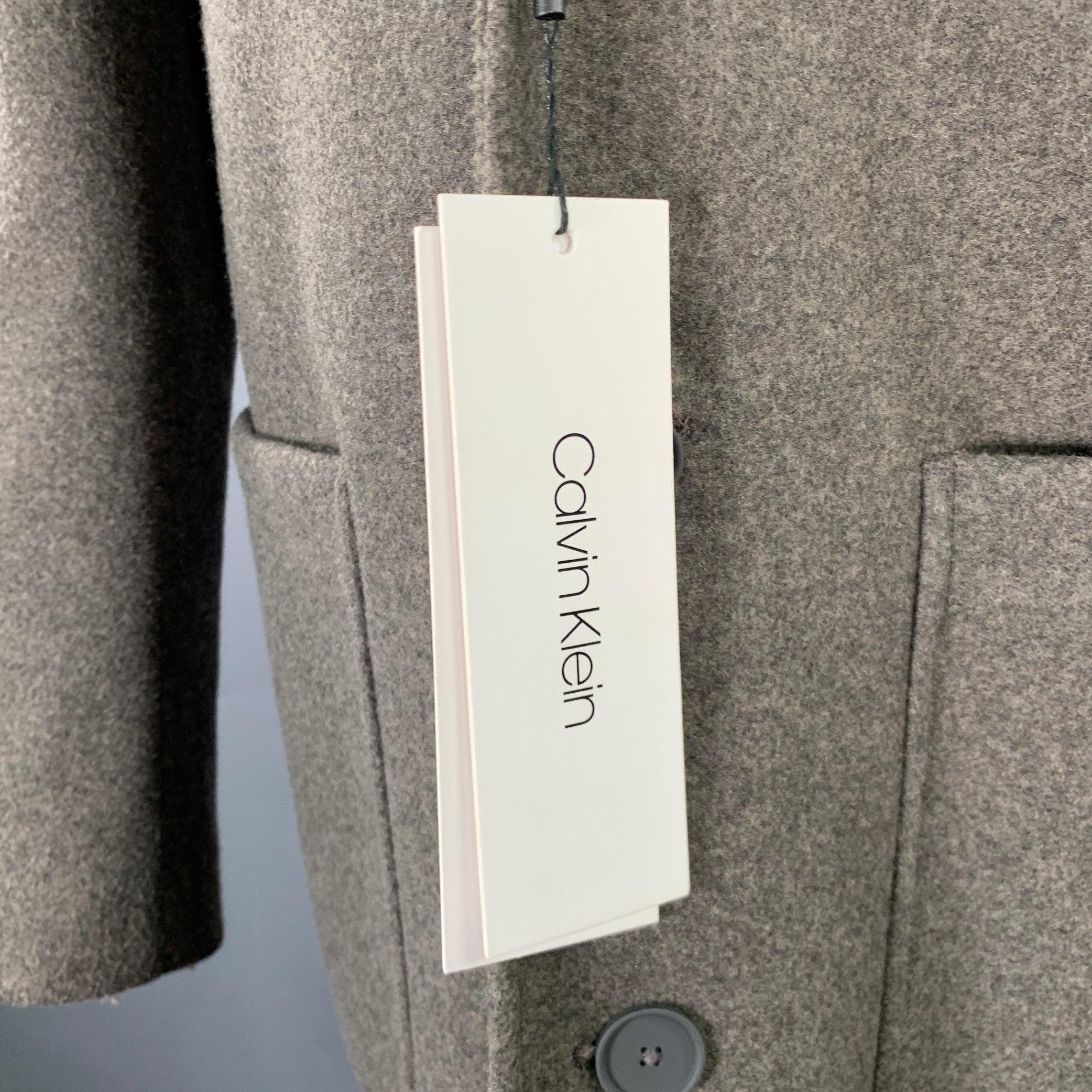Cappotto Calvin Klein
in tessuto misto poliestere grigio erica, con revers a lancia, due tasche e chiusura a tre bottoni.Nuovo con Fabrice. 

Contrassegnato:   36R 

Misure: 
 
Spalla: 17 pollici Petto: 39 pollici Maniche: 25 pollici Lunghezza: 38,5