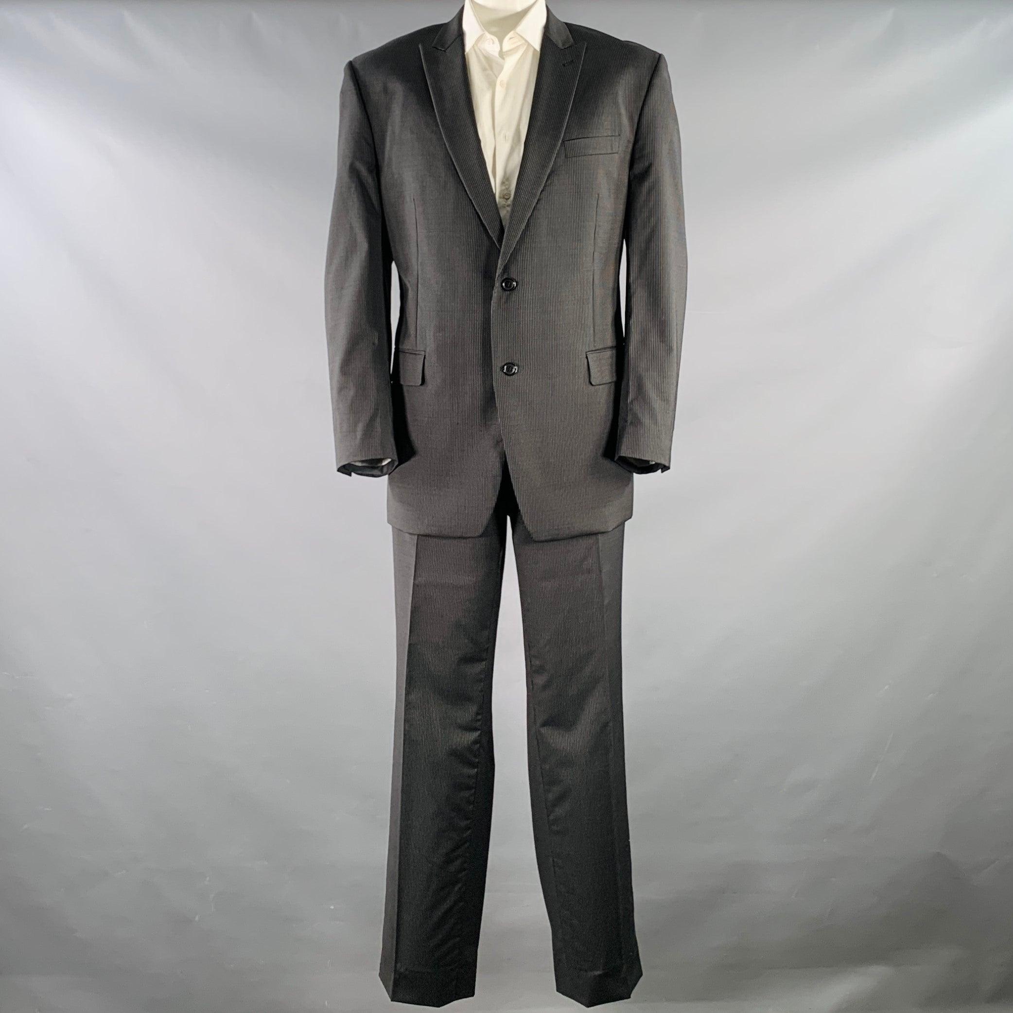 CALVIN KLEIN suit
in a black and white pinstripe wool with a full liner and includes a single breasted, double button sport coat with a peak lapel and matching flat front trousers.Very Good Pre-Owned Condition.
Minor signs of wear. 

Marked:   IT