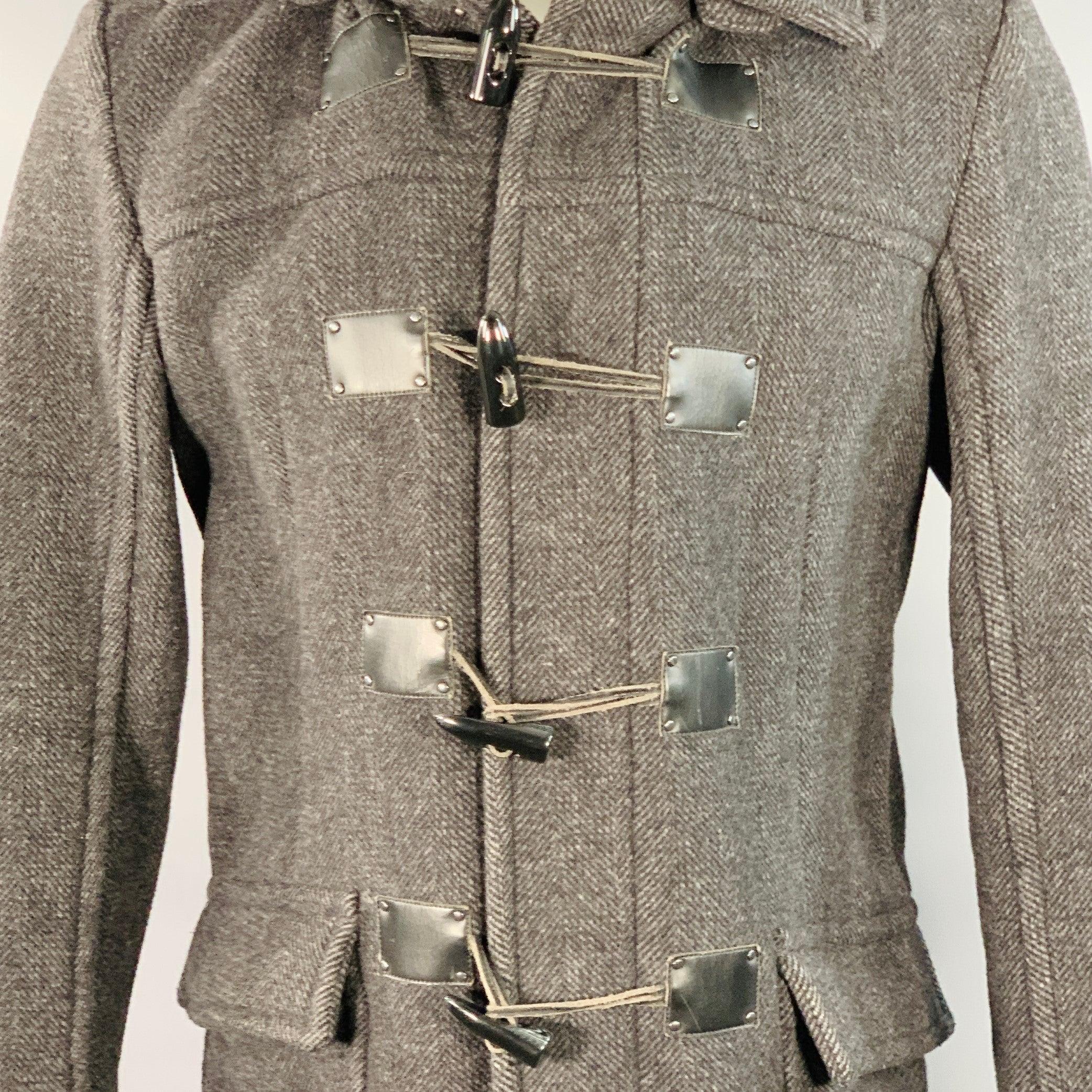 Abrigo CALVIN KLEIN
en tejido de mezcla de lana negro y gris marengo, con dibujo de espiga, capucha y cierre de velcro. Señales de desgaste en los parches de piel sintética cerca de las palancas. 

Marcado:   S 

Medidas: 
 
Hombro 17 pulgadas