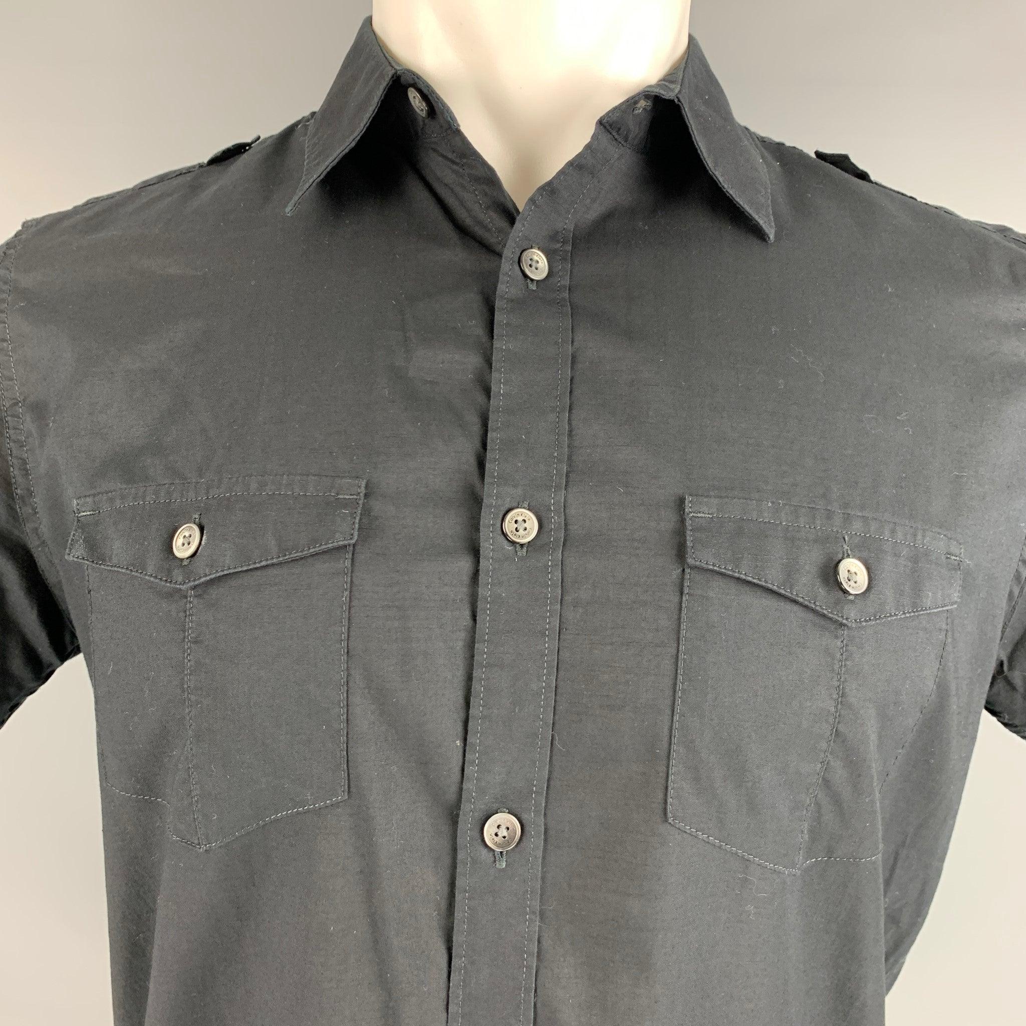 CALVIN KLEIN short sleeve
shirt in a black cotton fabric featuring short sleeves, epaulettes, two pockets,and a button up closure.Excellent Pre-Owned Condition. 

Marked:   S 

Measurements: 
 
Shoulder: 17 inches Chest: 40 inches Sleeve: 9 inches