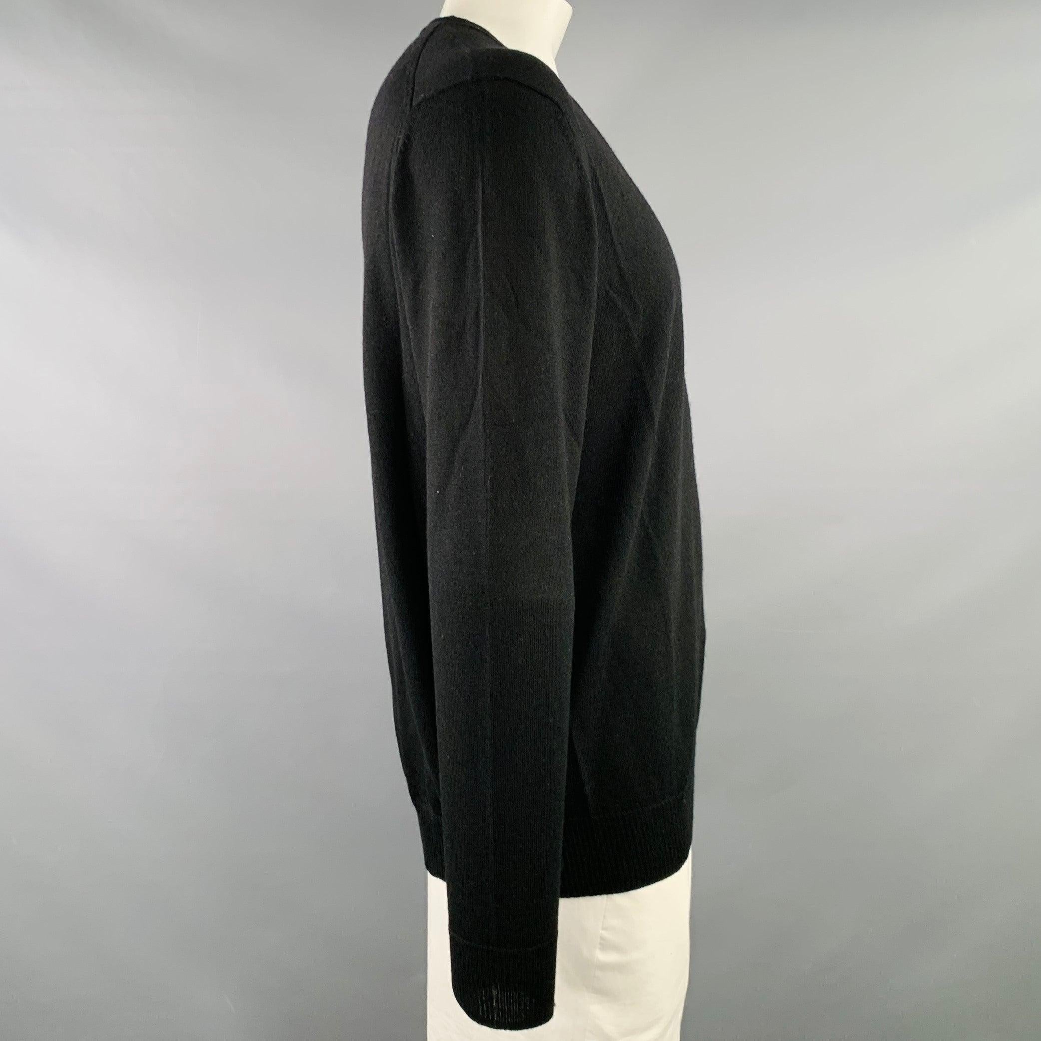 CALVIN KLEIN pullover
in a black merino wool knit featuring long sleeves and V-neck. Excellent Pre-Owned Condition. 

Marked:   XL 

Measurements: 
 
Shoulder: 19.5 inches Chest: 48 inches Sleeve: 26.5 inches Length: 29 inches 
  
  
 
Sui Generis