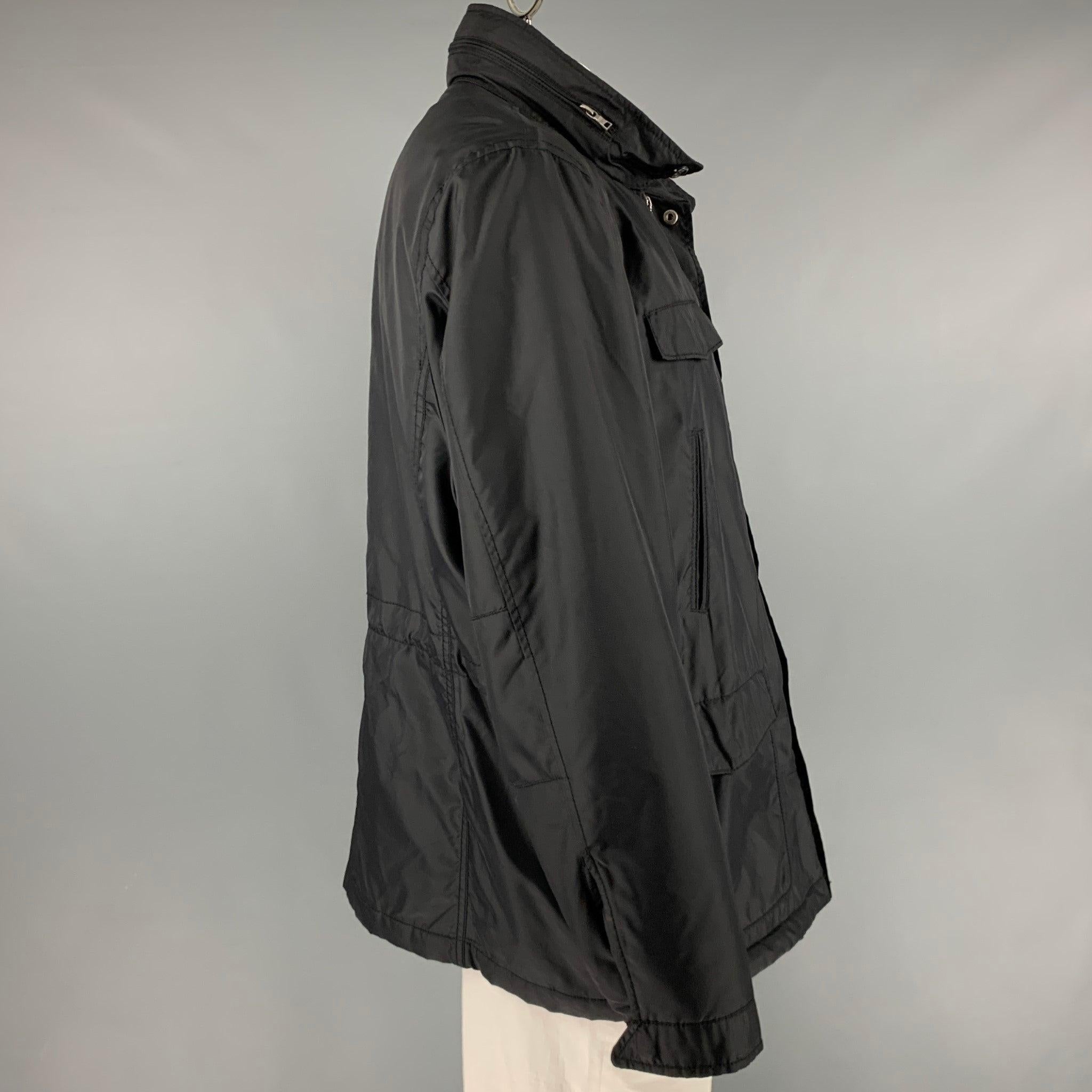 CALVIN KLEIN jacket
in a
black polyester fabric featuring multiple pockets, hidden hood, and zip up and snap closure.Excellent Pre-Owned Condition. 

Marked:   2XL 

Measurements: 
 
Shoulder: 18.5 inches Chest: 52 inches Sleeve: 26.5 inches Length: