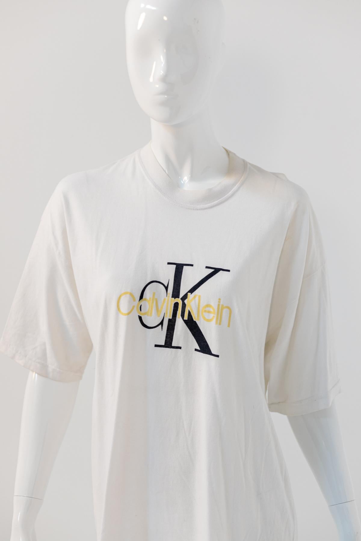 Magnifique T-shirt blanc surdimensionné de Calvin Klein datant de la fin des années 1990, avec logo et étiquette d'origine. Fait en Italie.
Le Whiting blanc est en coton long et oversize, avec des manches courtes.
Le logo officiel de Calvin Klein