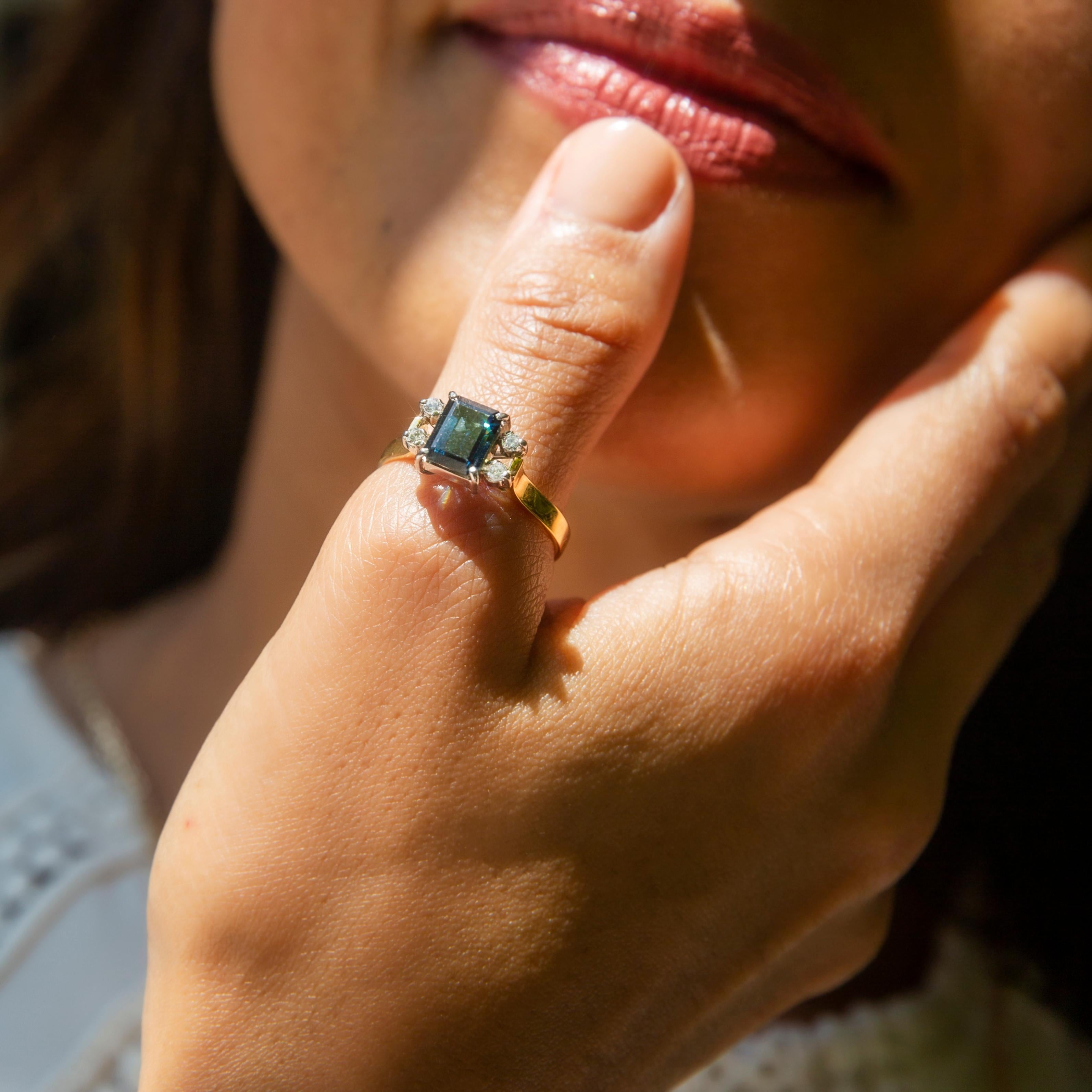 Under the veil of night we lay,
Destinies intertwined,
Stars shine forth to guide the way,
Our fates forever aligned.

Calypso is set with an emerald cut teal & deep blue sapphire with a quartet of brilliant cut diamonds. 

The Calypso Ring Gem