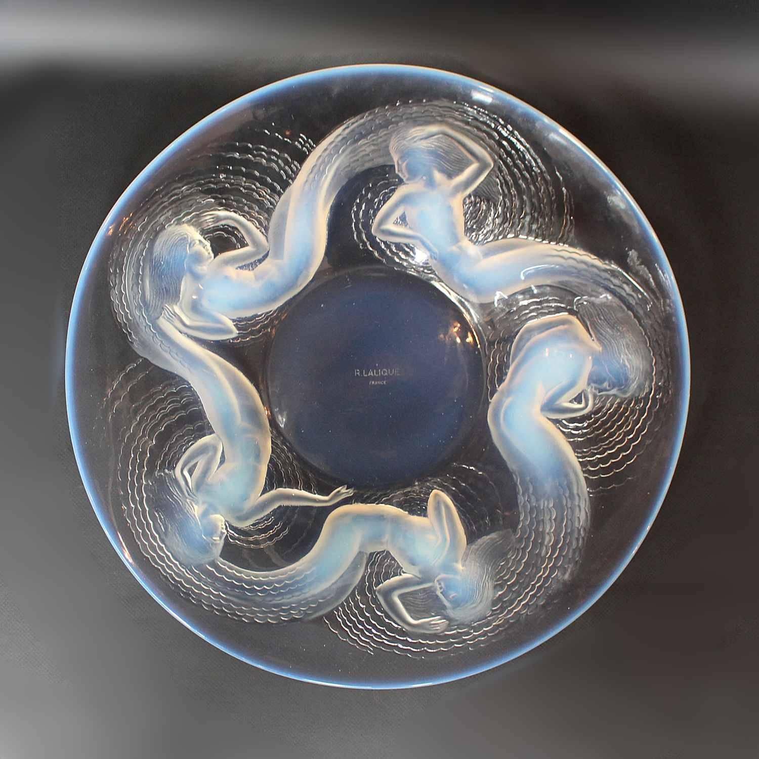 Calypso Charger, an opalescent and clear glass charger by René Lalique, with raised swirling water nymphs decoration. 

Marcilhac Catalogue Raisonné de L'œvre de Verre p.461

Artist: René Lalique.
 