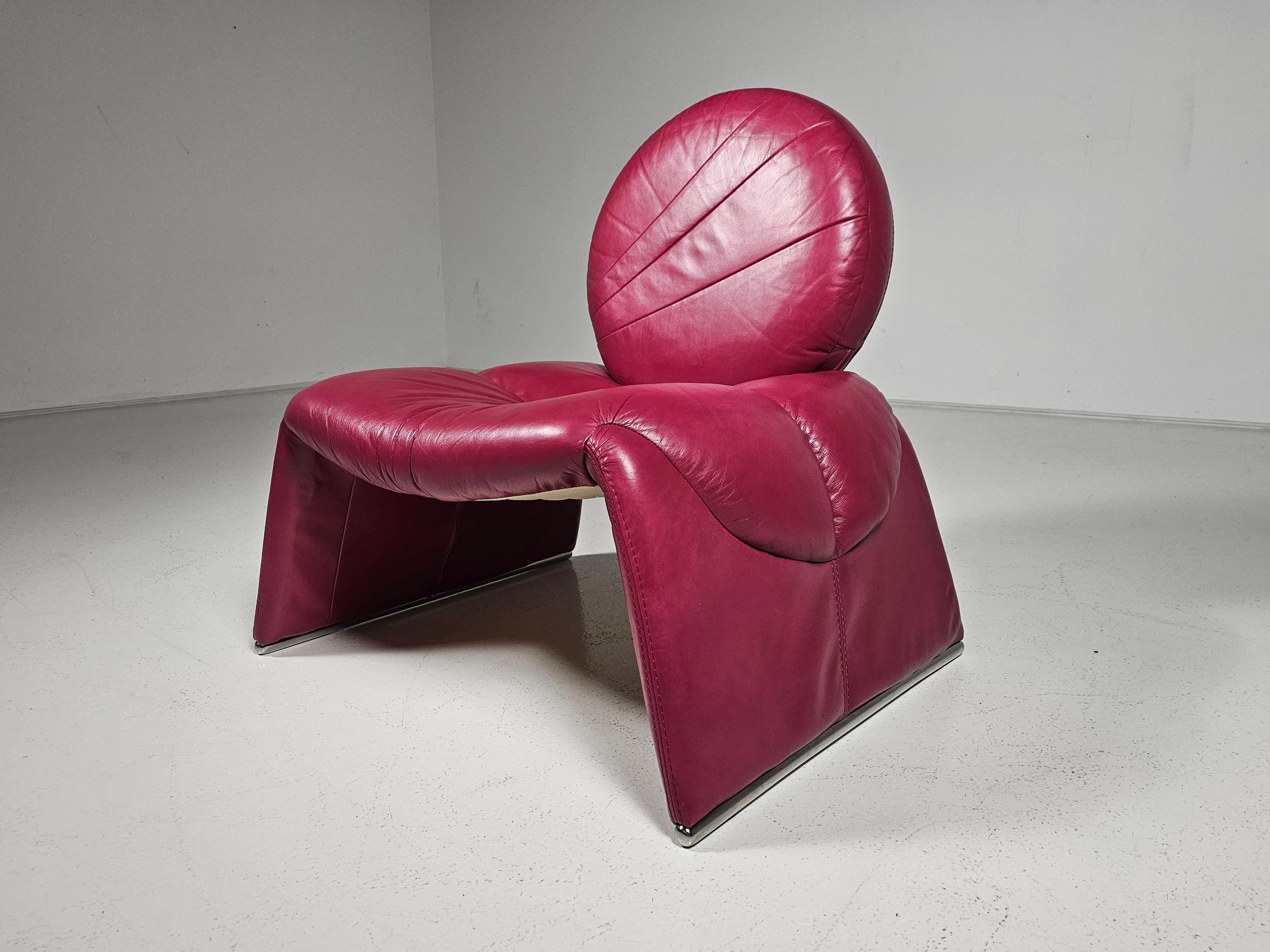 Silla de salón Calypso original de Vittorio Introini, una obra maestra atemporal diseñada en 1979 y fabricada por Saporiti en Italia. La silla tiene un asiento de piel rosa oscuro con aspecto de cascada y un respaldo redondo de piel. En el asiento