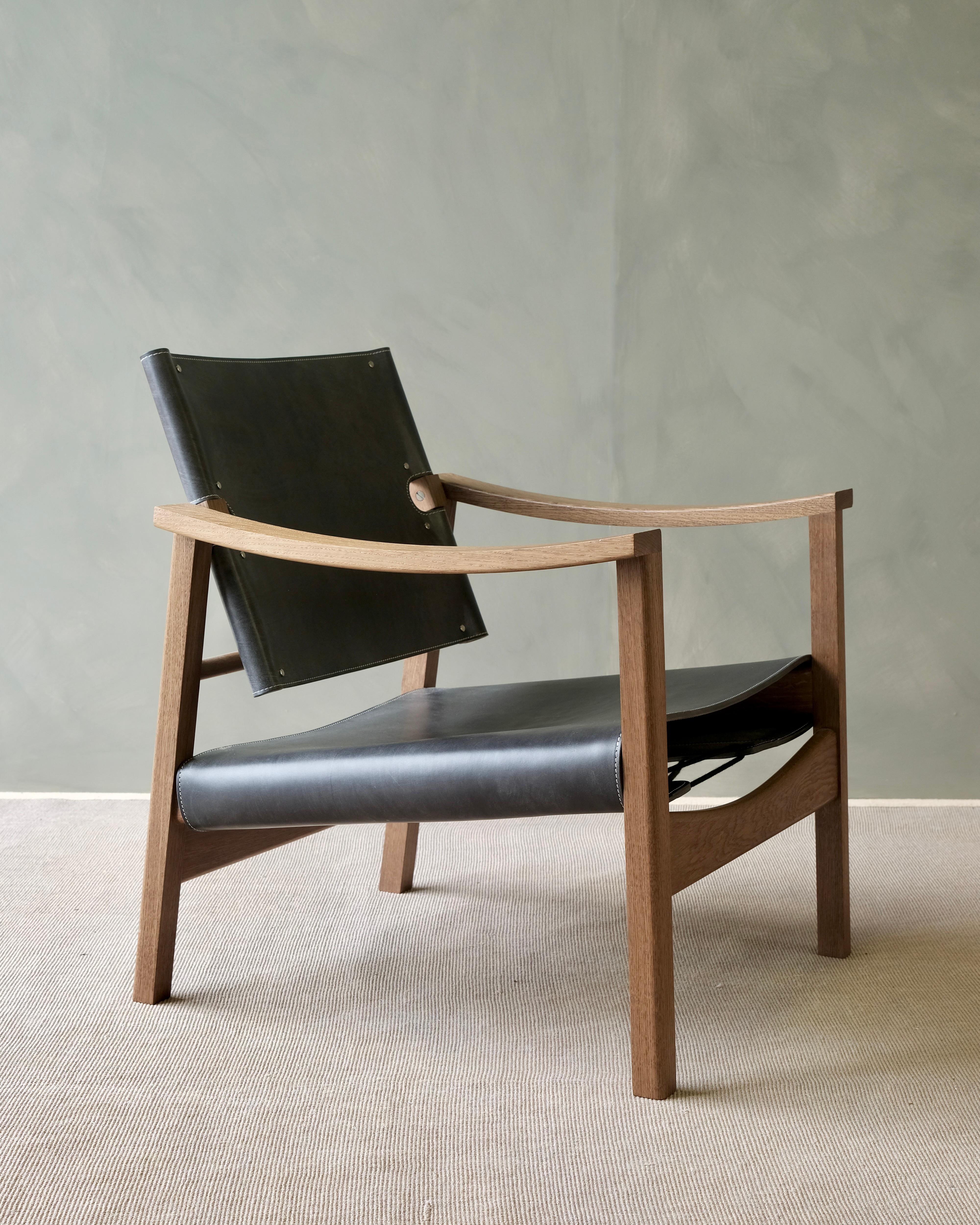 The Camber reading chair is refined and beautifully poised, with a gentle sculpted bow in the arm rests and slight angle on the subtly profiled legs. Using the finest oak bark bridle leathers and pit tanned leather cord from Britain's last remaining