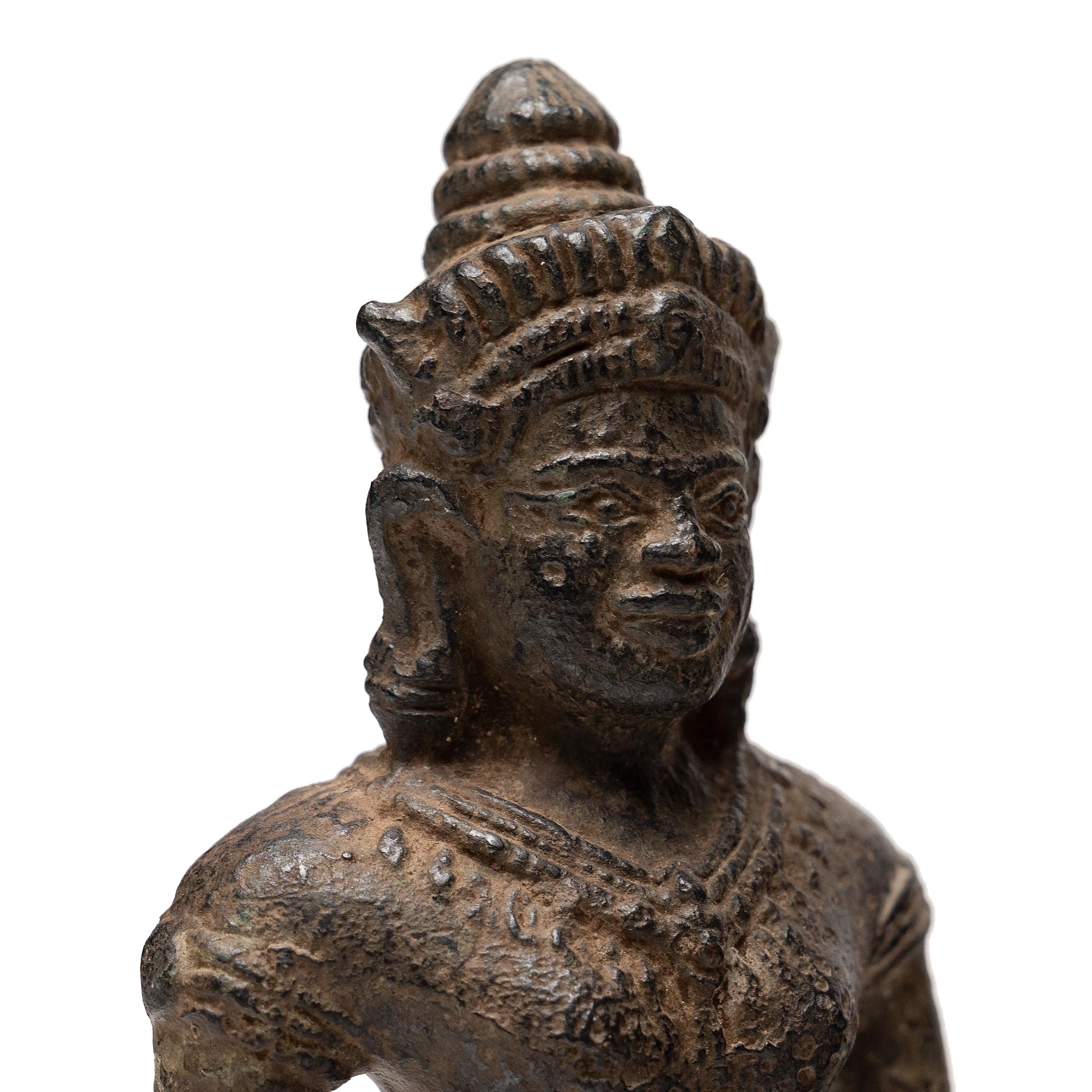 Sculptée à la manière de la statuaire khmère, cette figure de dévotion en bronze coulé représente une divinité bouddhiste debout, probablement la déesse bien-aimée Lakshmi. Figure centrale de la mythologie hindoue, Lakshmi est également vénérée par