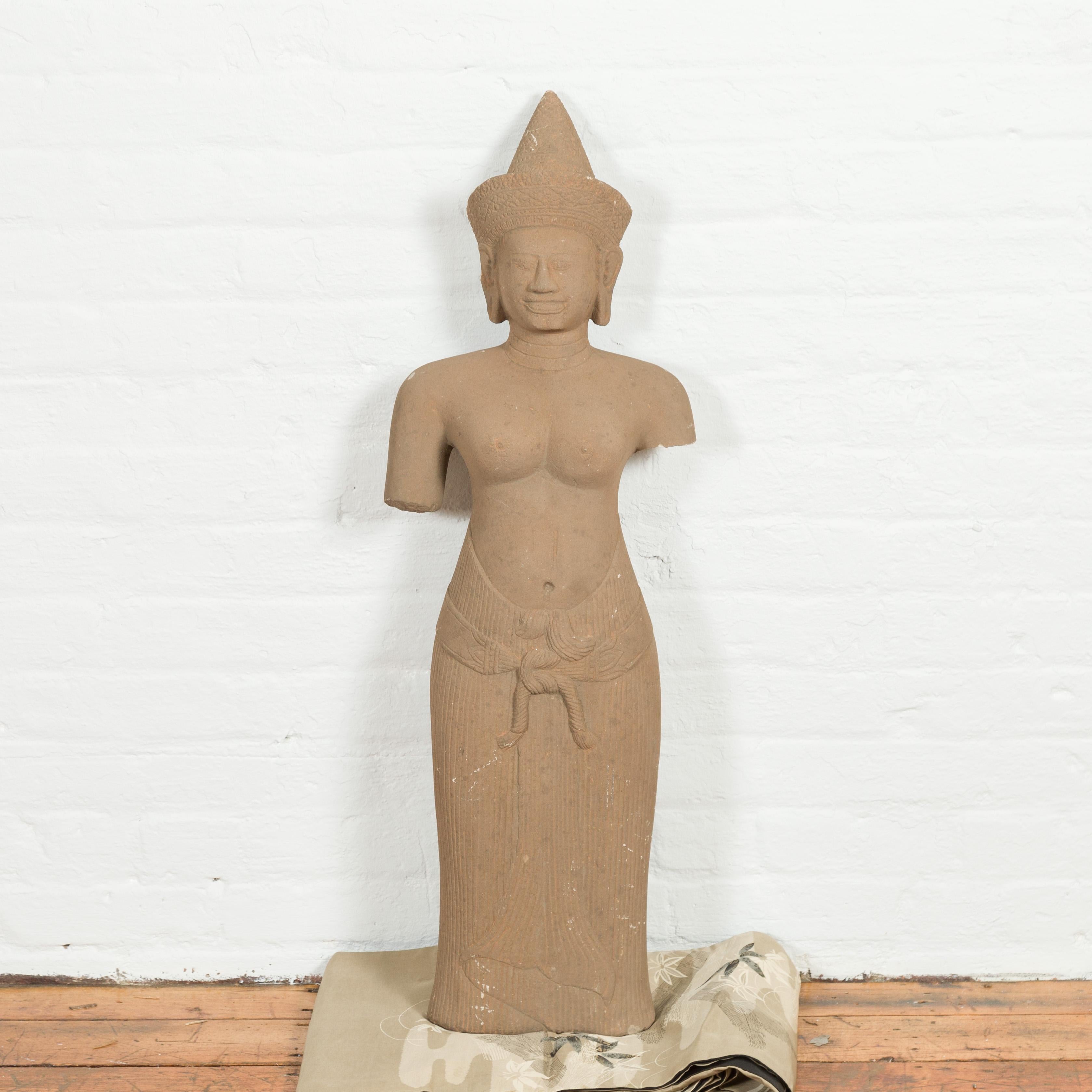 An antique Cambodian carved sandstone female deity torso from the early 20th century, with headdress and custom reclining base. Created in Cambodia, this statue can be displayed standing up or reclining on a flat base. Two old holes, now plugged,