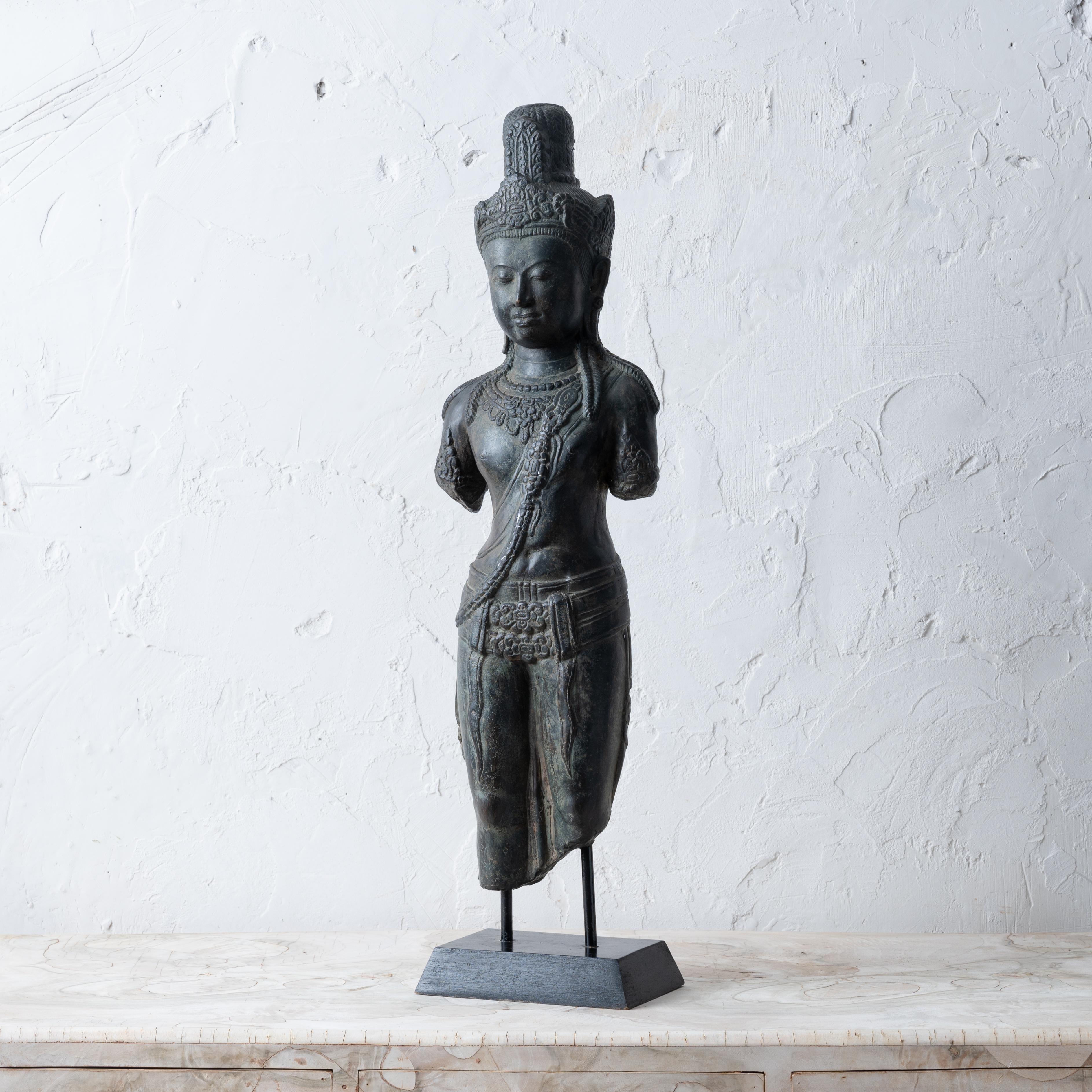A Cambodian Khmer bronze fragmentary figure in the manner of the art of the Angkor Wat period, 20th century.

7 inches wide by 5 inches deep by 27 ½ inches tall

