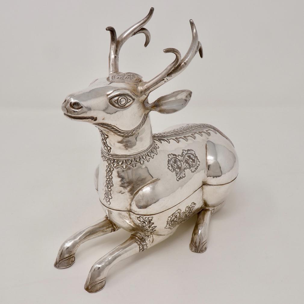 Cambodian Silver Stag Box. A traditional sturdy crouching stag form with front legs stretched out before him and the hind legs slightly splayed underneath. The hammered silver  with foliate design on the smooth body with a pair of three branch