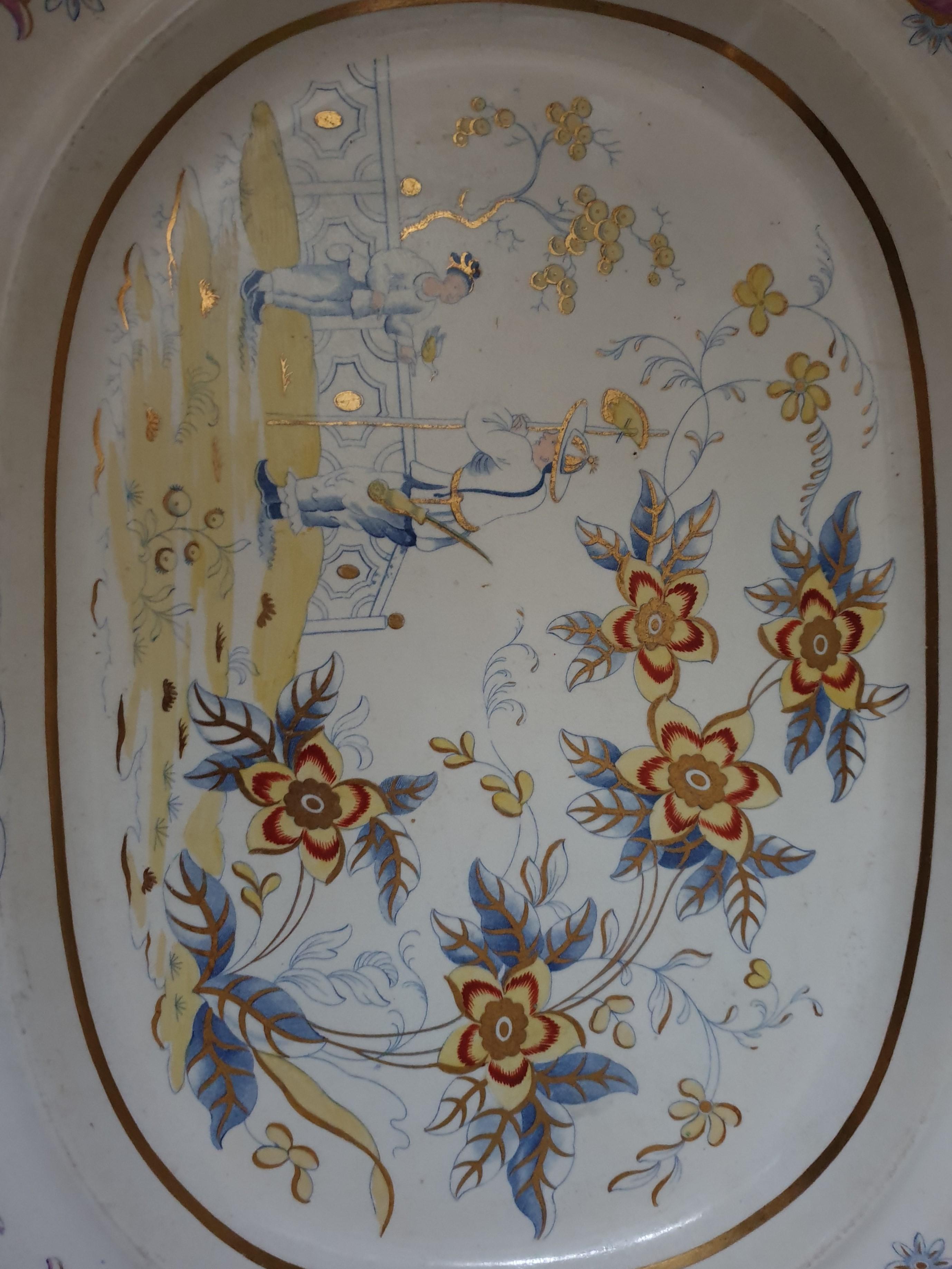 A Cambria pattern earthenware Platter printed in blue and yellow in a Chinoiserie design highlighted with red and gilt. Manufactured by Charles Heathcote & Co, and features The Prince of Wales Three-Feather Crest which appears on printed
