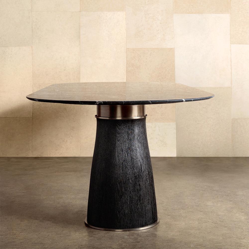 The Camden double pedestal dining table unites organic materiality and a Classic double-pedestal silhouette. This racetrack-shaped table features two solid, natural oak bases. The jewelry-like details of the foot and collar elevate the table to a