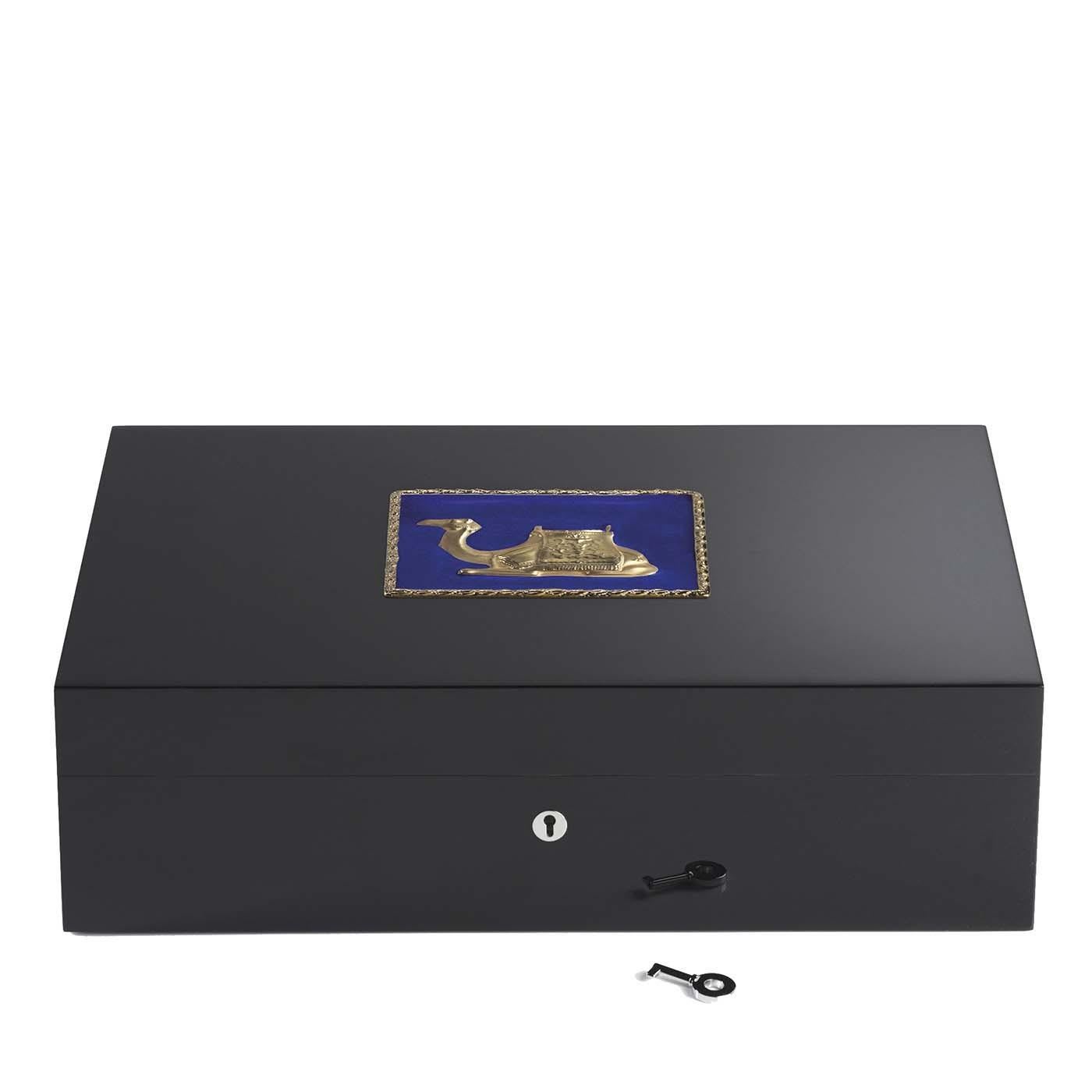 An exquisite example of Italian craftsmanship, this wooden humidor boasts a square decoration on the lid portraying a finely depicted camel on a blue background. The golden edges framing the decoration share with the camel the same luminous finish.
