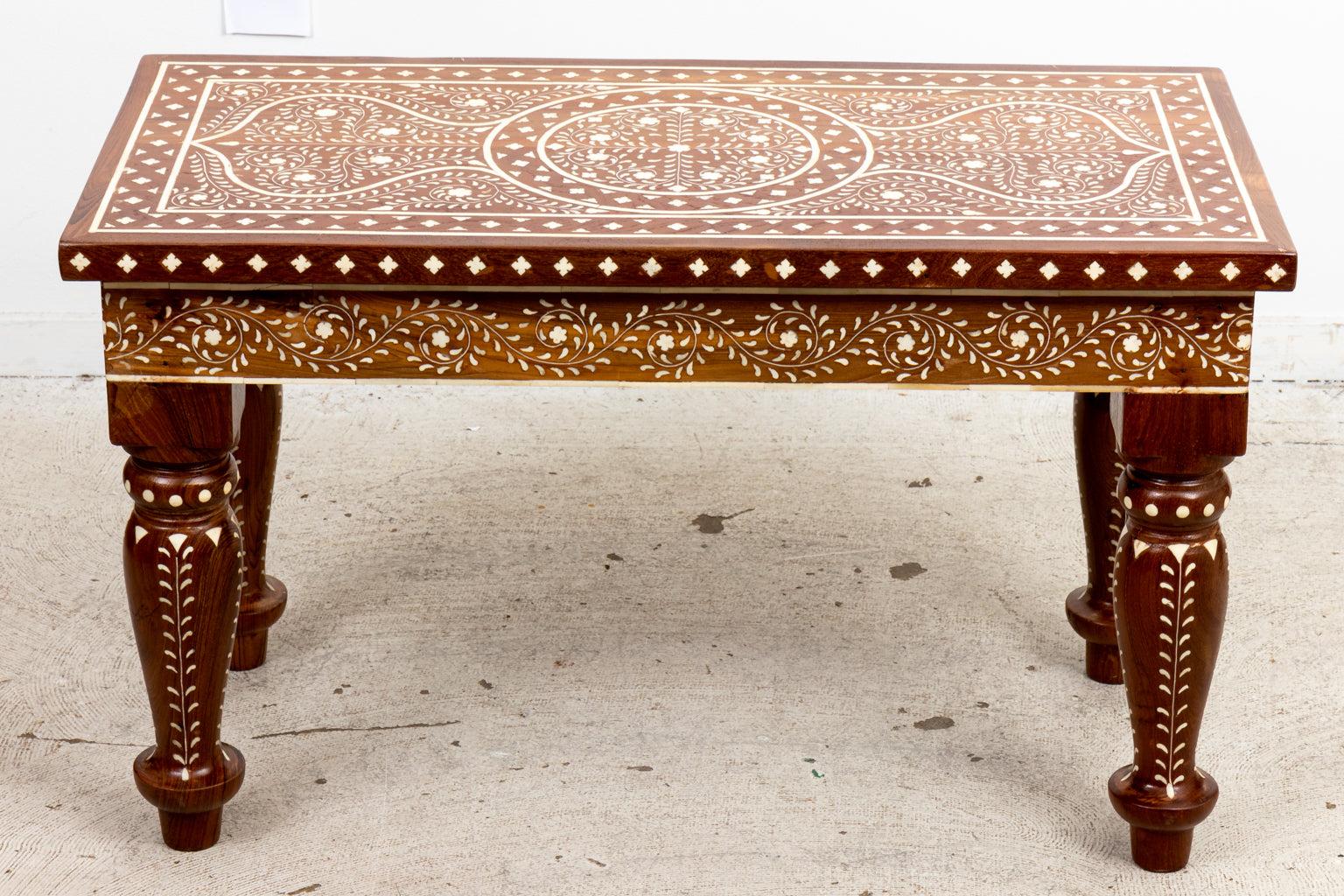 Wood coffee table on vase turned legs inlaid throughout with white camel bone. The inlay is crafted in the shape of geometric motifs as seen on the table top. Please note of wear consistent with age.