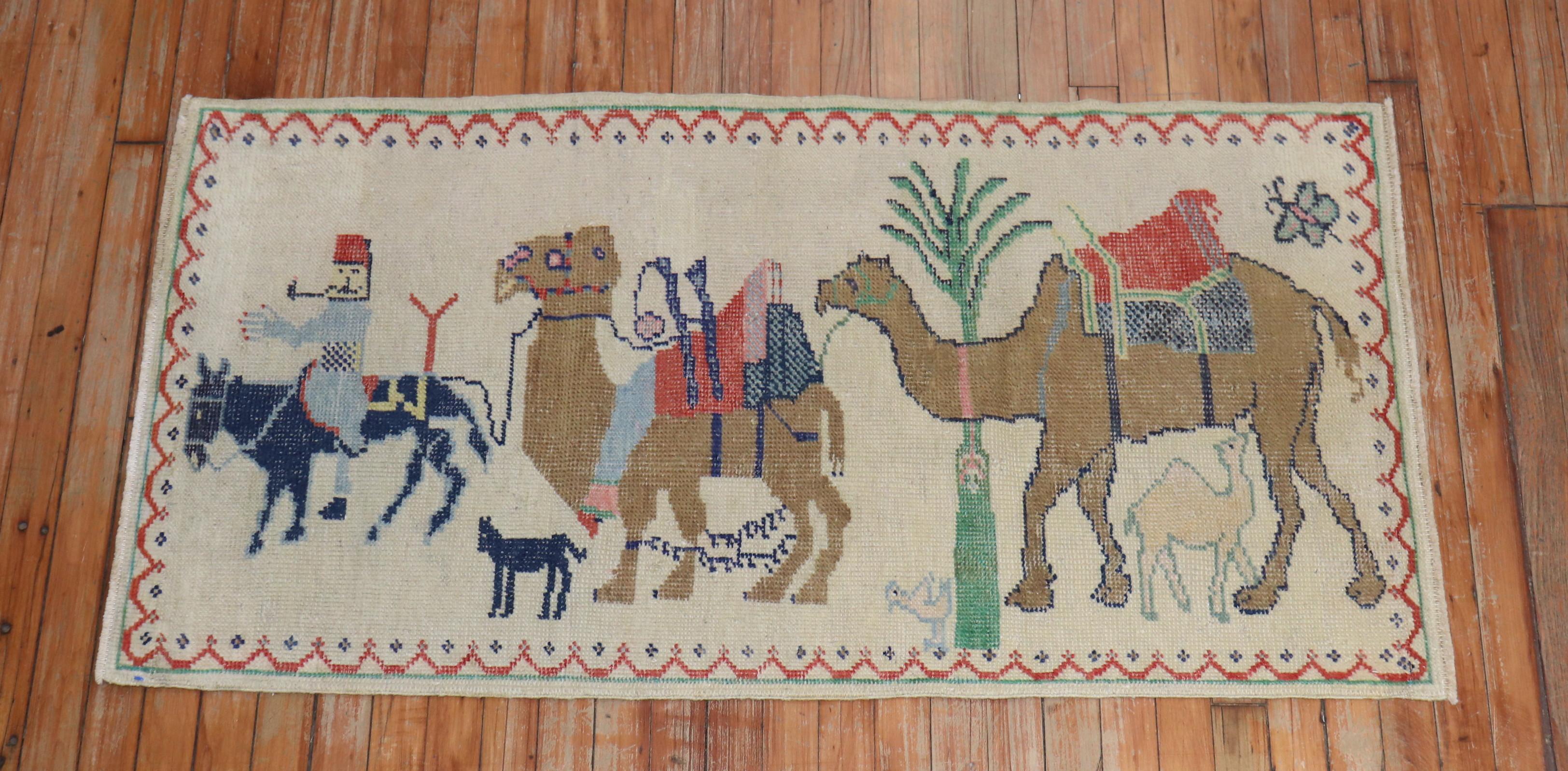 Mid 20th century Turkish Anatolian rug with a pictorial scene with a man riding on his horse strolling a donkey and a camel on an ivory field
Size: 2'5'' x 4'7''.