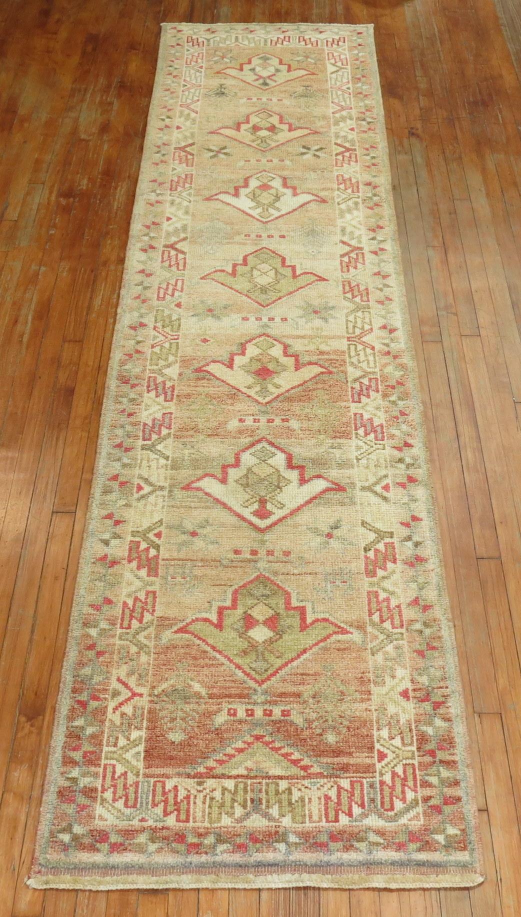 Turkish Anatolian runner with a simple multi medallion motif on a camel ground from the middle of the 20th century. 

Measures: 2'10” x 12'2”.