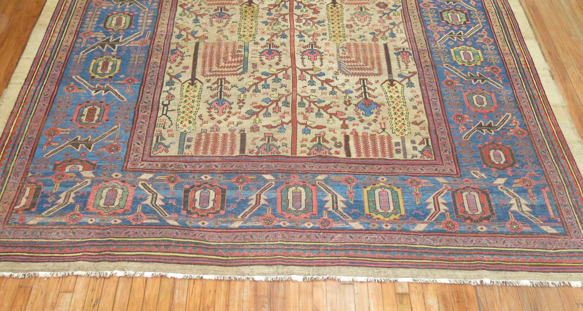 Camel field 19th century Persian Bakshaish rug featuring a large scale tree of light design on a camel field surrounded by a large sky blue border

Bakshaish carpets are some of the most highly sought after and elite carpets produced in the 19th