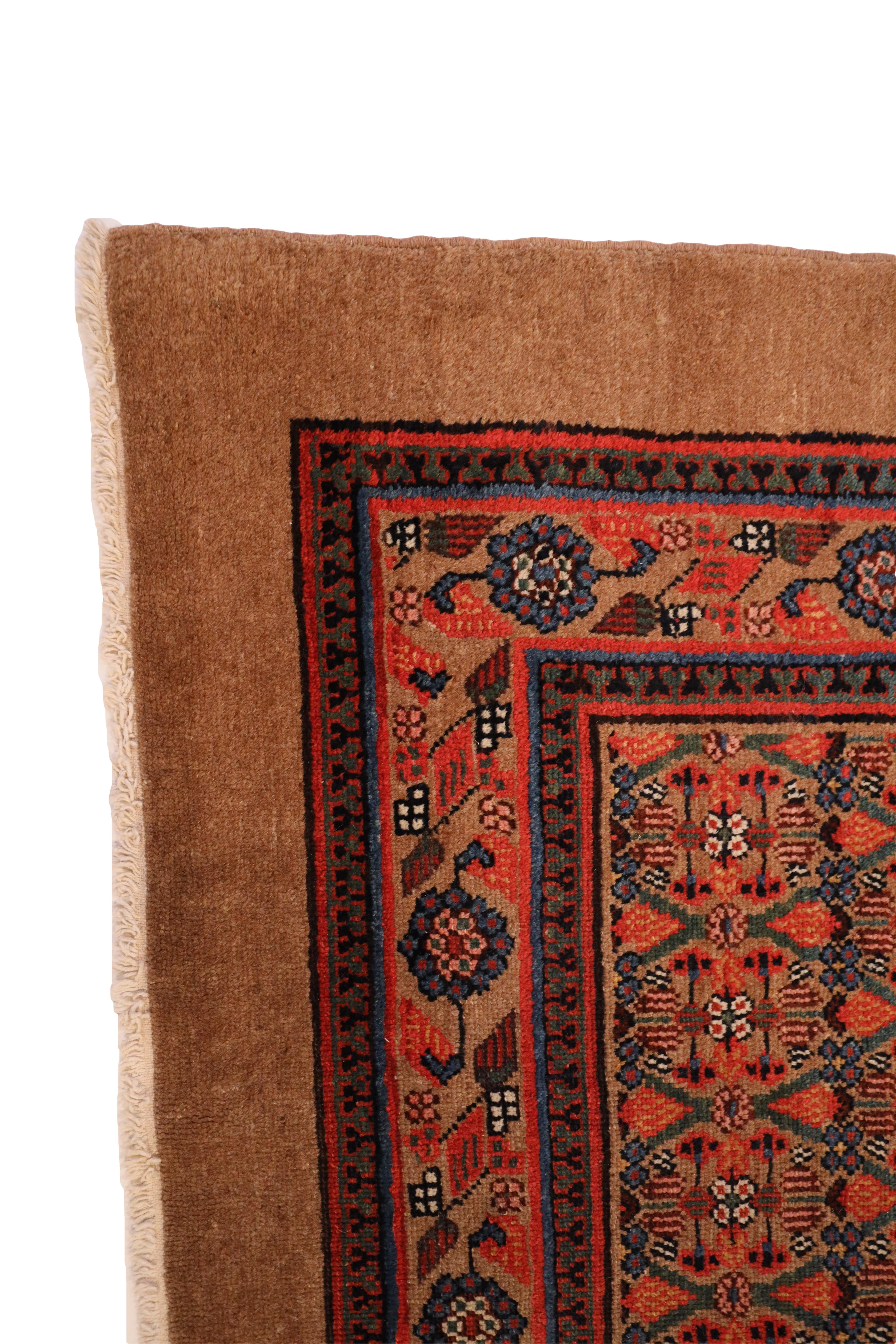 This antique Hamedan camel hair rug is a true gem, showcasing the timeless beauty of traditional Persian rug weaving. The rug features a deep beige camel hair color that exudes warmth and richness, creating a luxurious foundation for its intricate