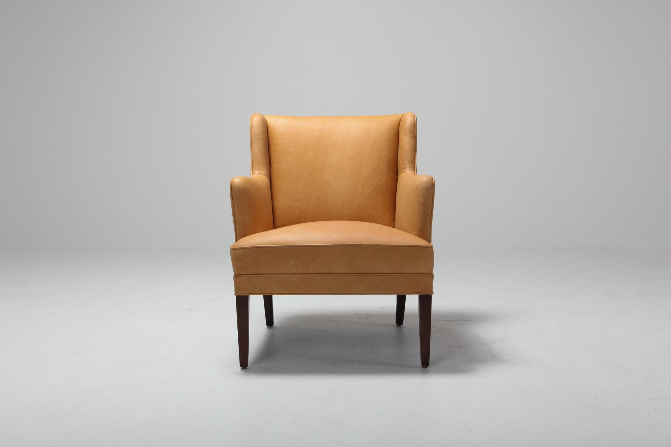 Midcentury Scandinavian Modern armchair in camel colored leather 
Reminds a bit of the designs of Nana Ditzel and Arne Norell.
 
 