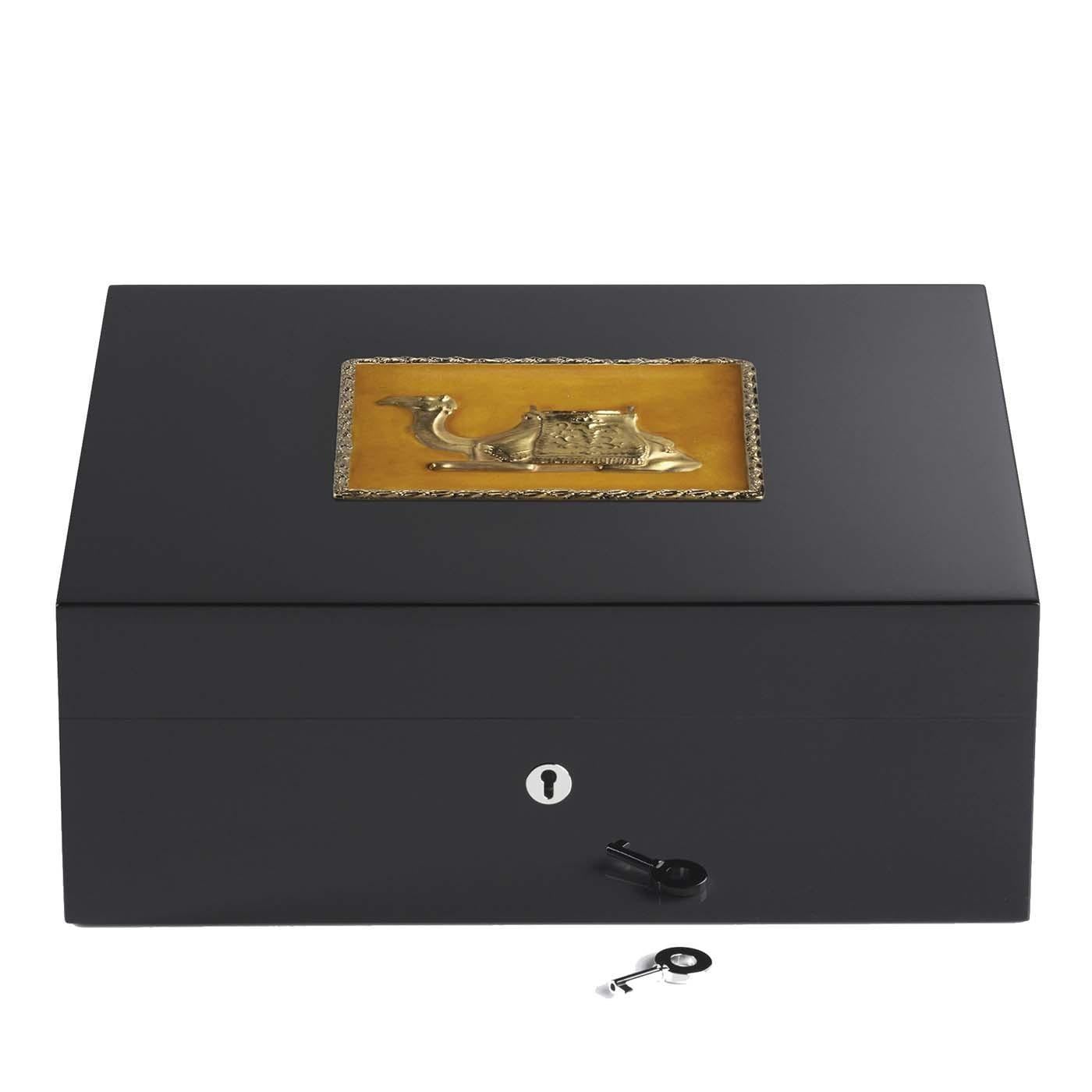 This stunning wooden humidor boasts an elegant black Silhouette that can contain up to 75 cigars. The detailed reproduction of a camel graces the top of the lid and showcases an ocher-colored background with golden edges that matches the camel's