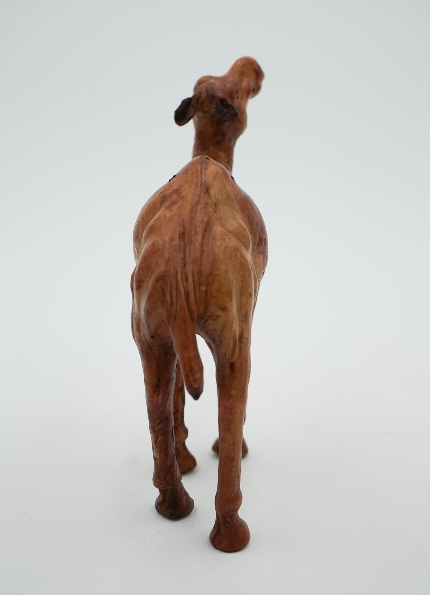 ESCULTURA DE CAMELLO CON  CUERO ENVEJECIDO SOBRE MADERA TALLADA A MANO DE LiBERTY'S LONDRES siglo XX en venta