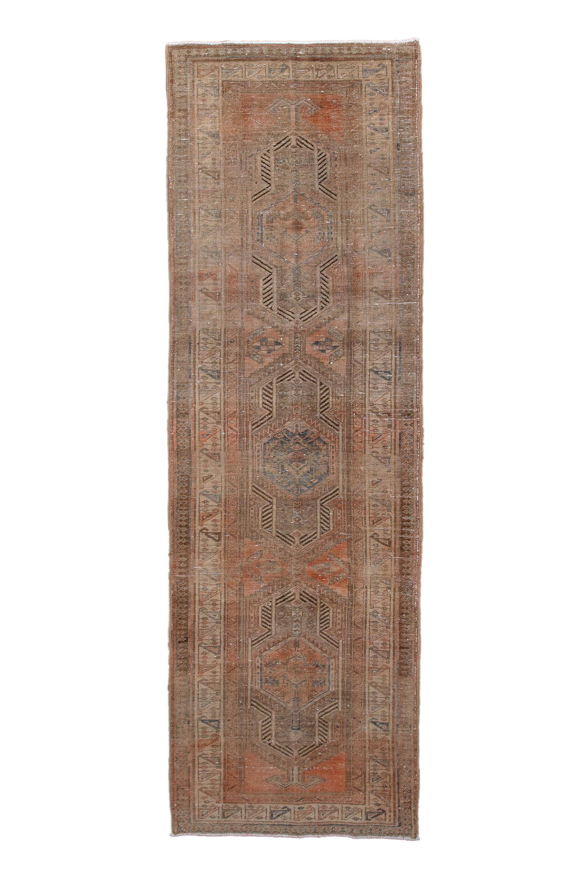 Runner or long rug? The camel-tone ground hosts  three indented cartouches with prominent comb decorations, with secondary trapezoidal side fillers.  Eggshell border with unusual triangular reversing botehs and straight line sprigs.  Moderate weave,