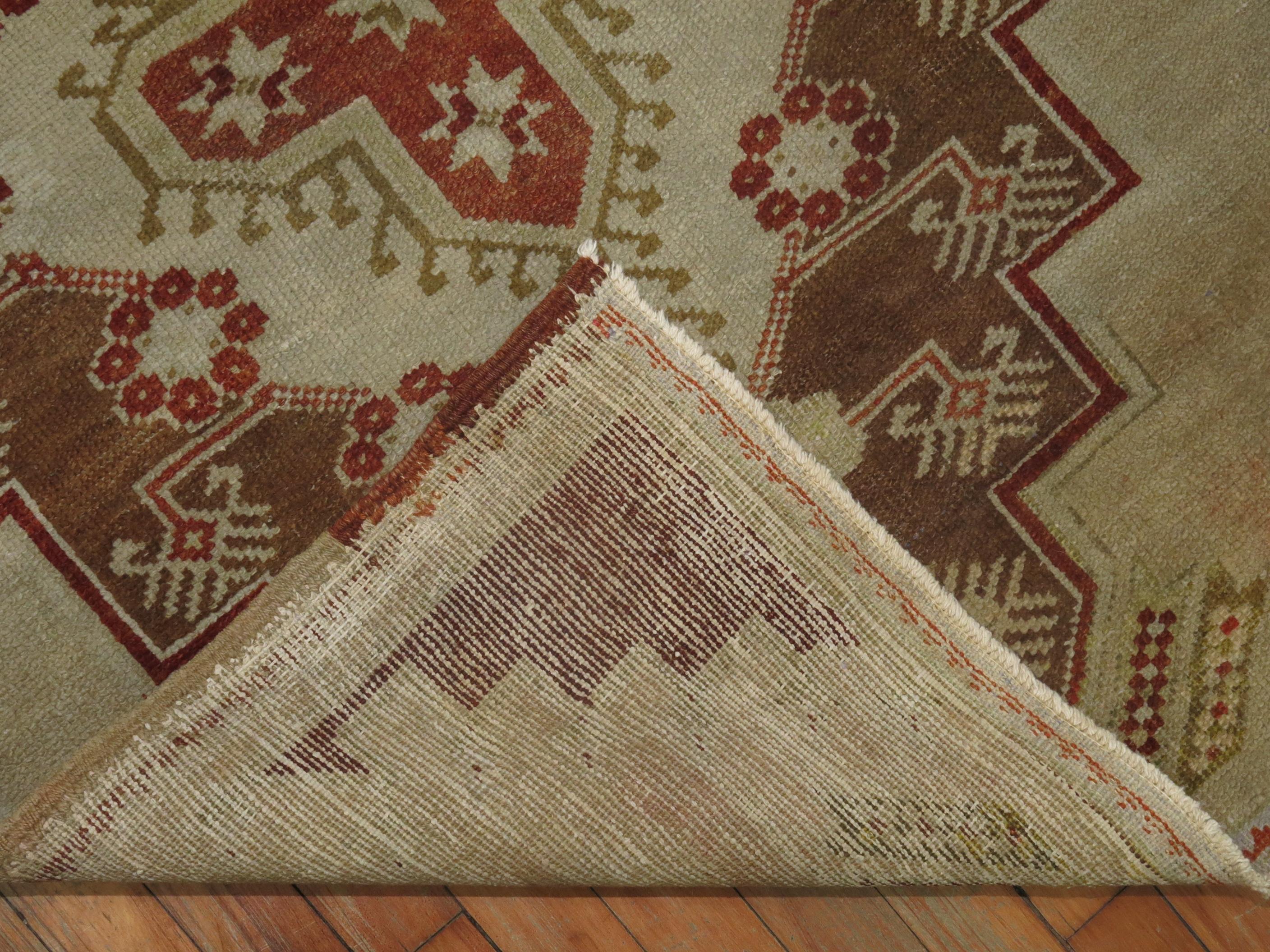 Vintage Turkish Oushak rug in burnt reds, brown accents on a camel field.