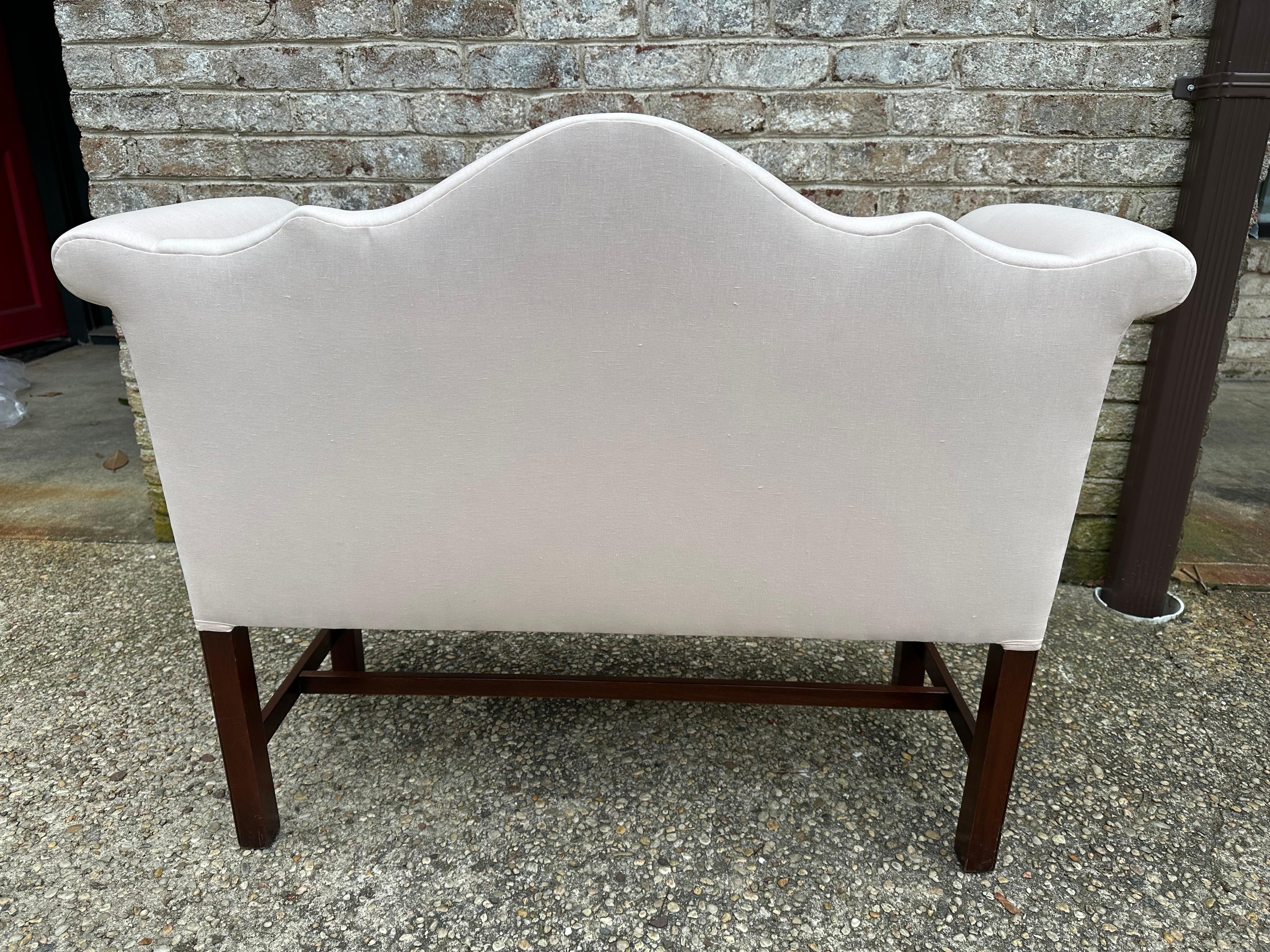 Lovely and graceful camel back bench..... newly upholstered in light pink linen that can be upholstered over like muslin.... Chippendale style legs.