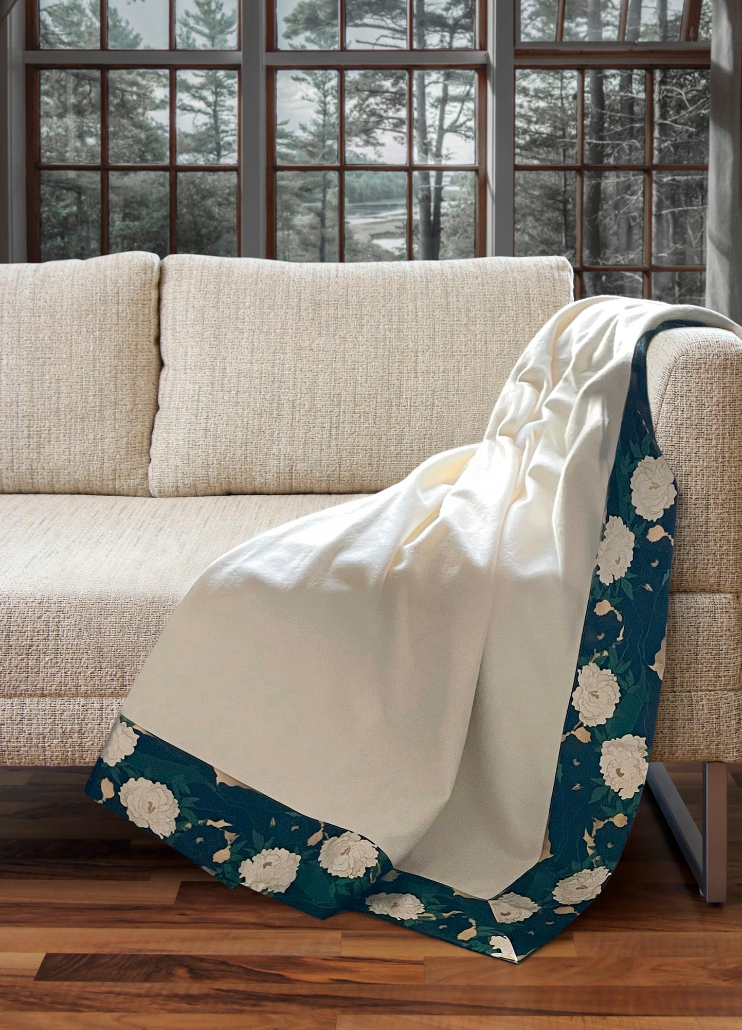 Cette superbe couverture en 100% cachemire blanc Loro Piana interiors avec un bord richement imprimé de pivoines en soie est la pièce ultra luxueuse pour tout salon élégant.
