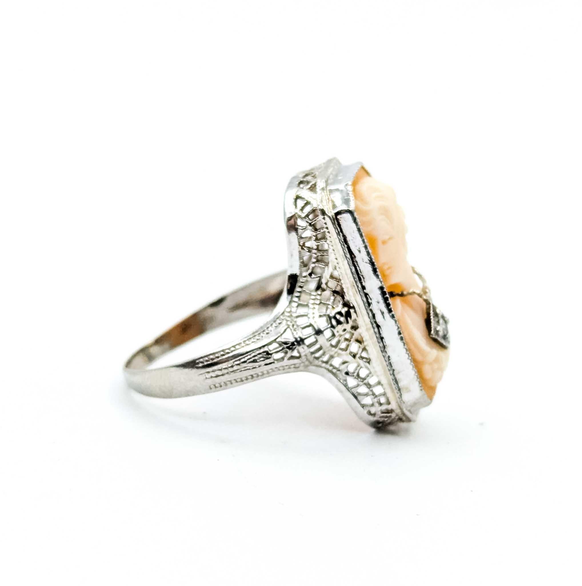Anillo Art Decó de oro blanco de 10k con camafeo y diamantes

Te presentamos este exquisito anillo Art Decó, elaborado en oro blanco de 10 quilates, con un encantador camafeo en el centro. El anillo está adornado con un delicado diamante de 0,01