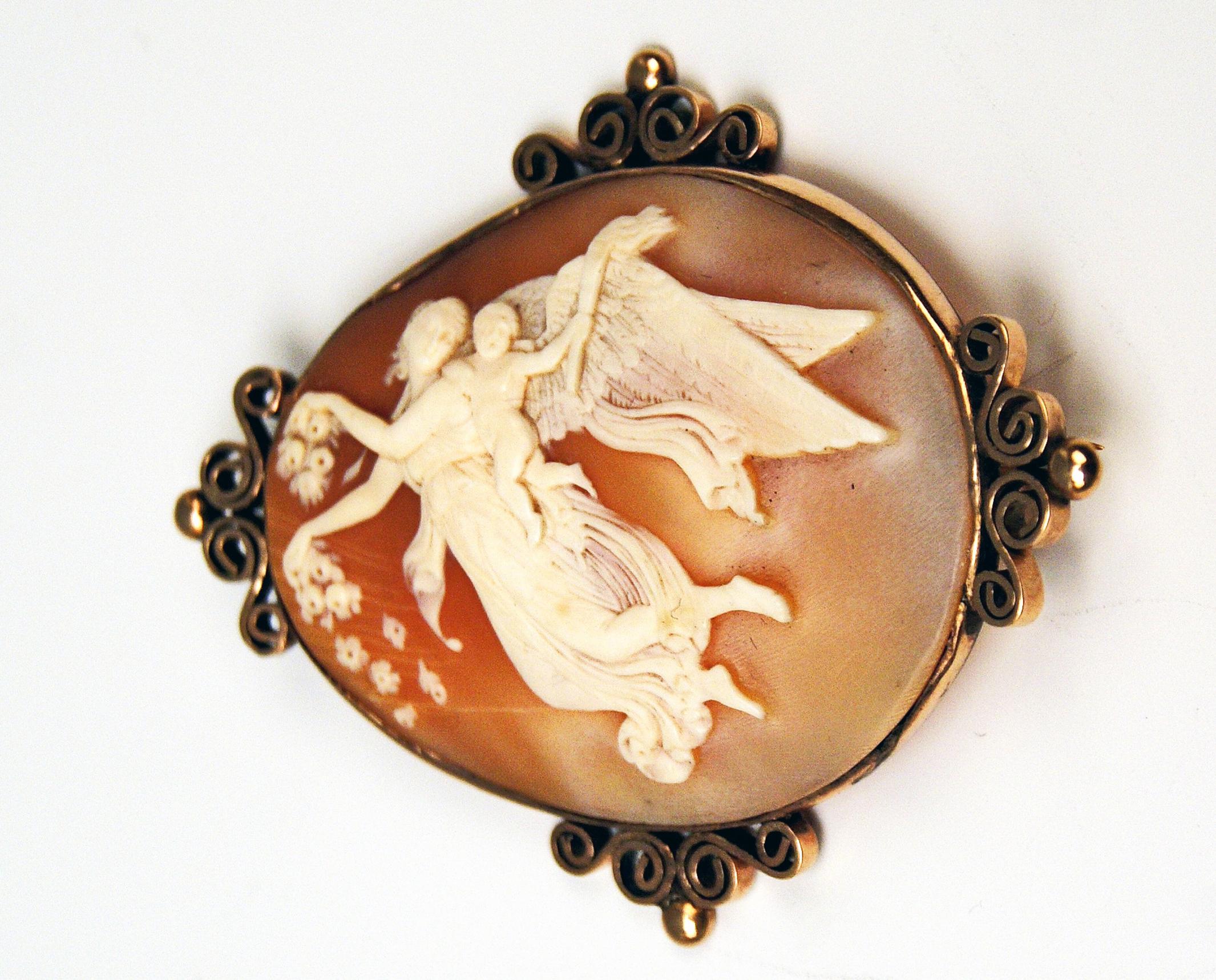 Very interesting cameo brooch made during Viennese Historicism Period: 
The rose red brooch made of shell is of oval form type to which following figurines are attached in the technique of the relief:  A winged nymph floating in air scatters